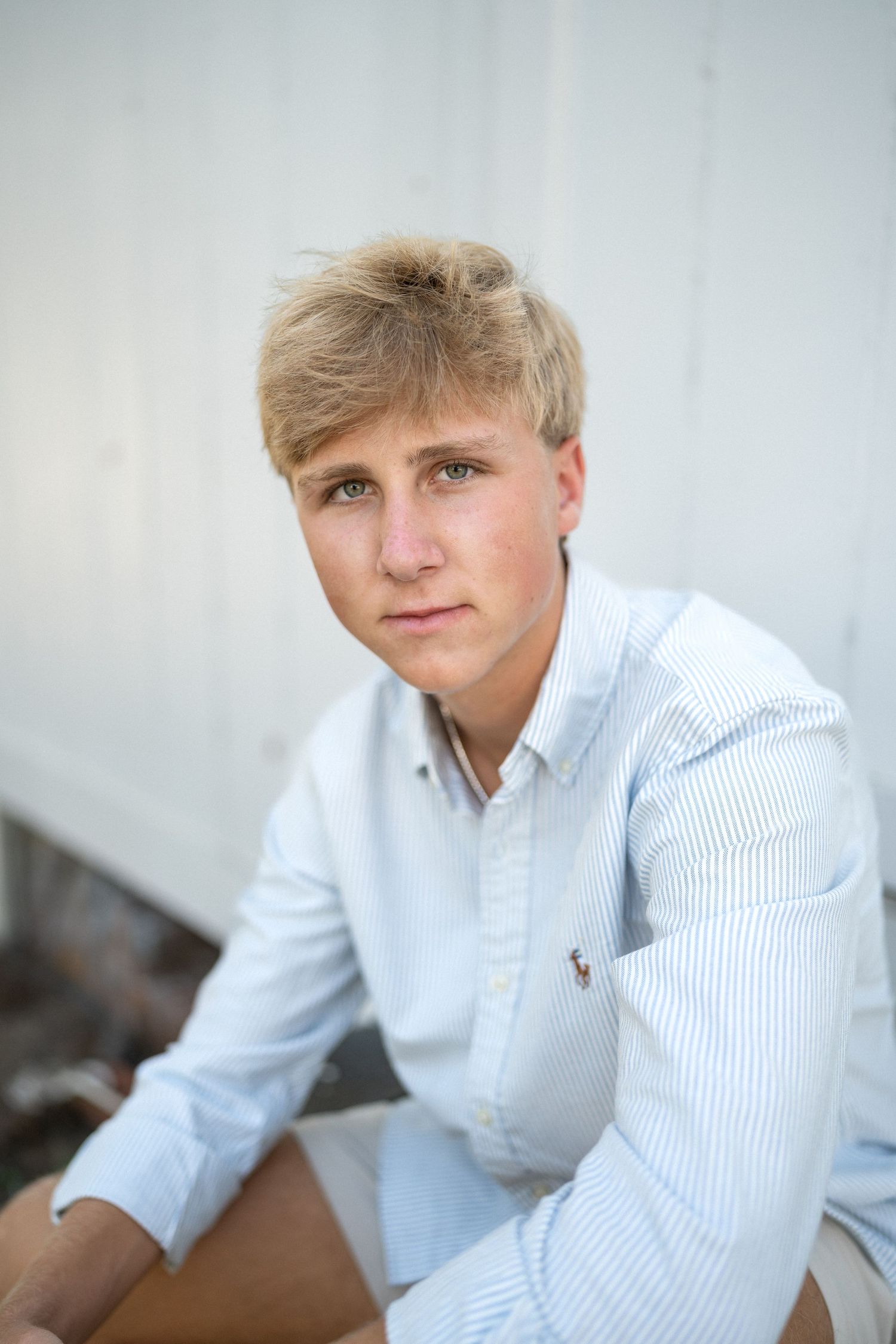 Close-up high school senior guy portrait at white barn in North Carolina
