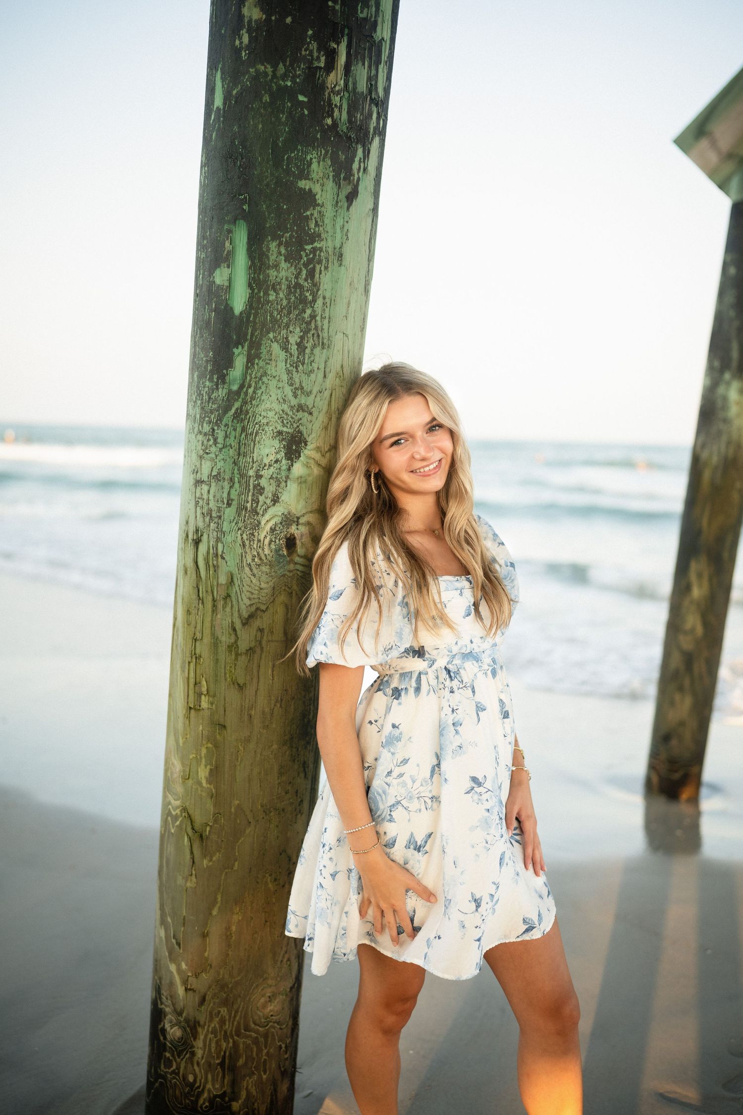Senior portrait of Sydney at Wilmington, NC pier, showcasing a ocean backdrop during a beachside photo session