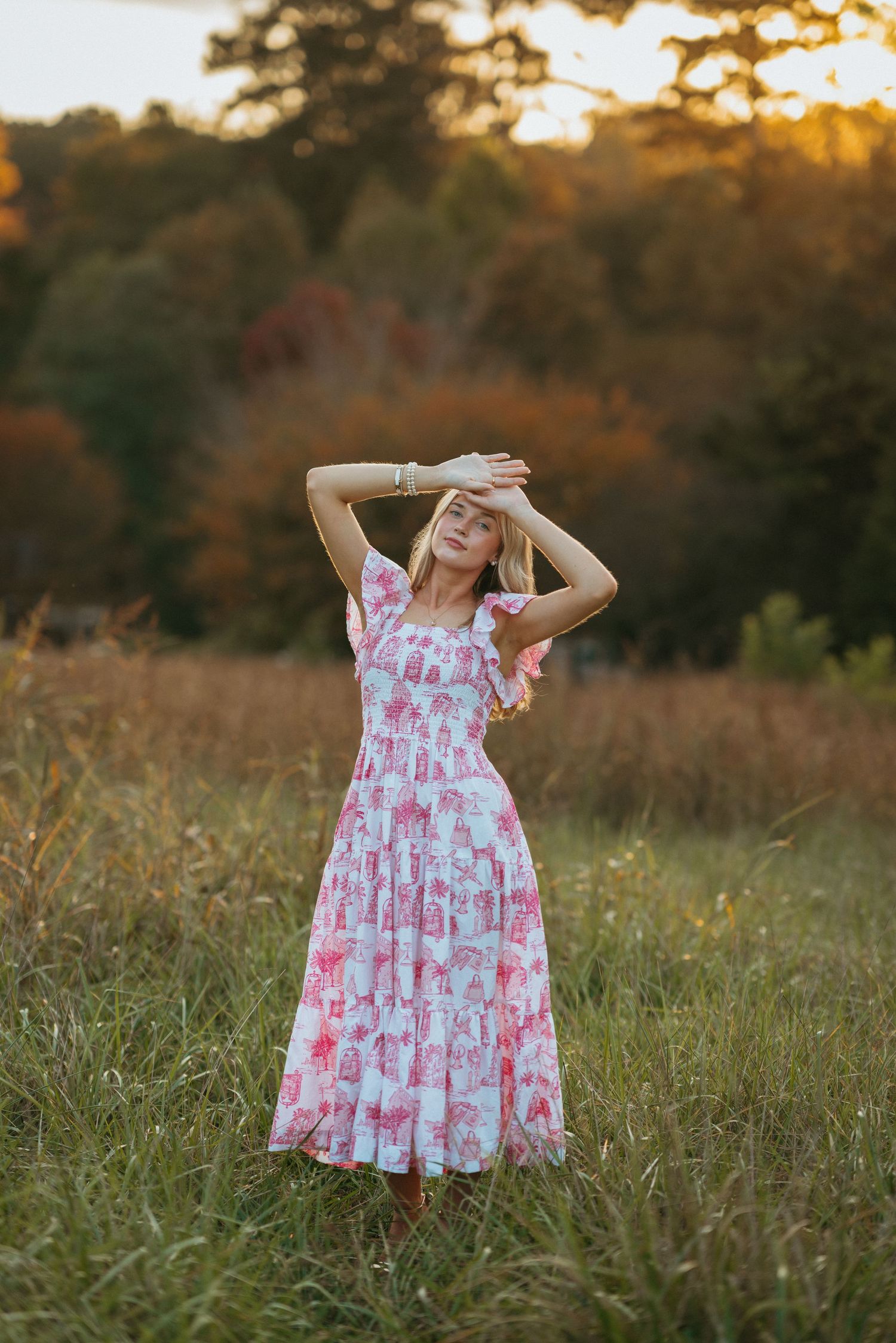 High school senior girl posing with her arms raised at Historic Yates Mill County Park in Raleigh.
