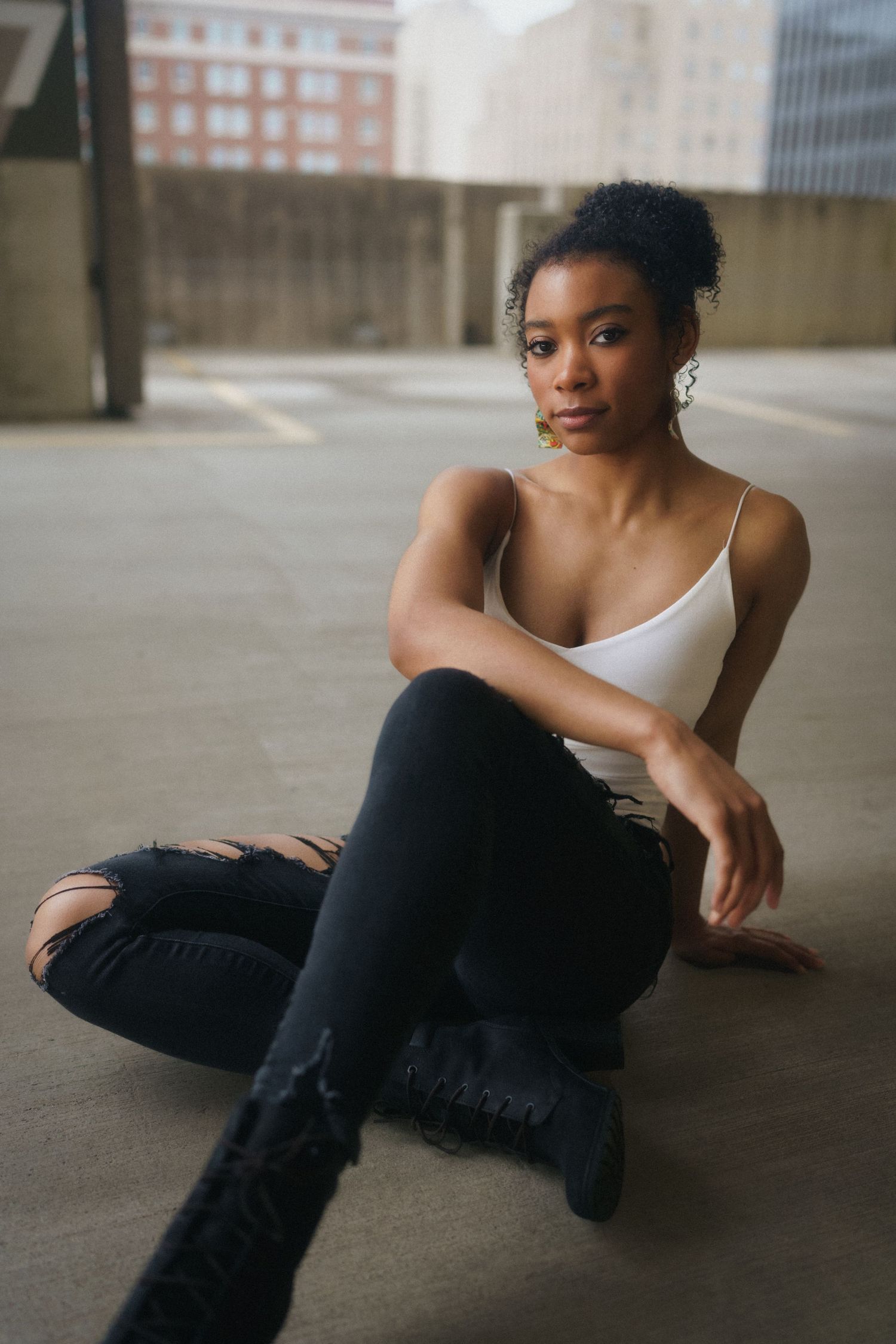 High school senior girl sitting on a parking deck in downtown Raleigh.