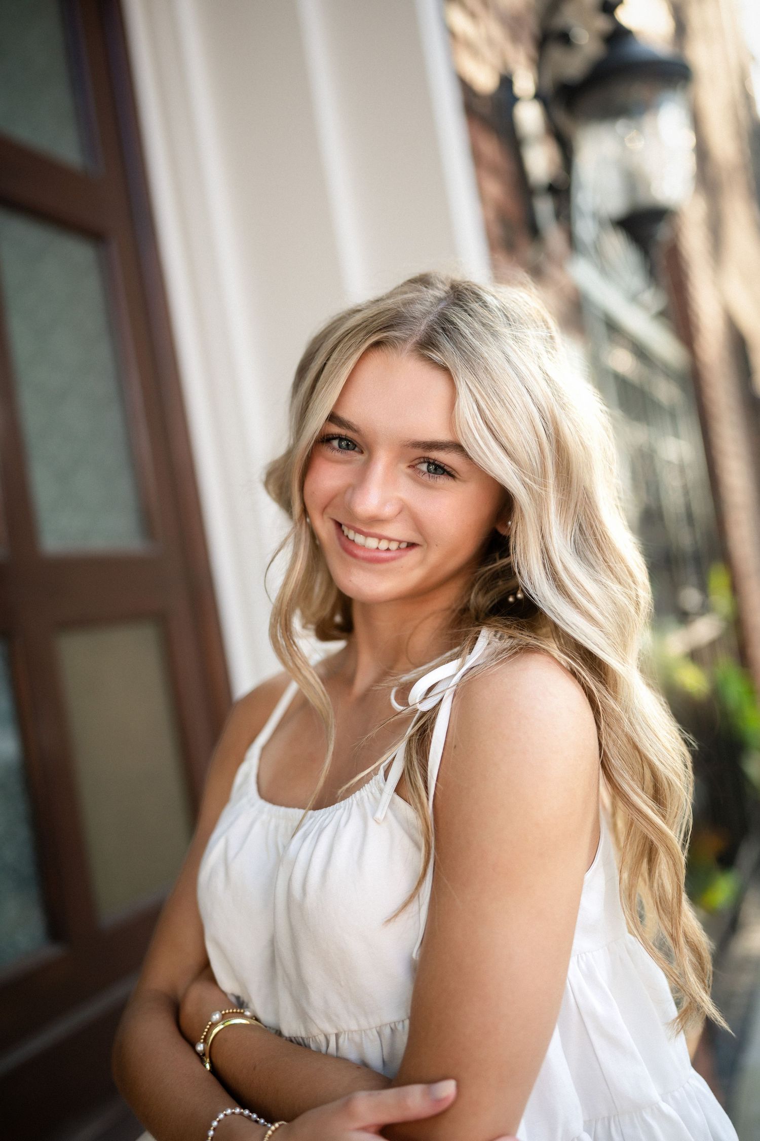 Sydney's senior portrait at a gated home entrance in downtown Wilmington, NC, featuring elegant ironwork and greenery