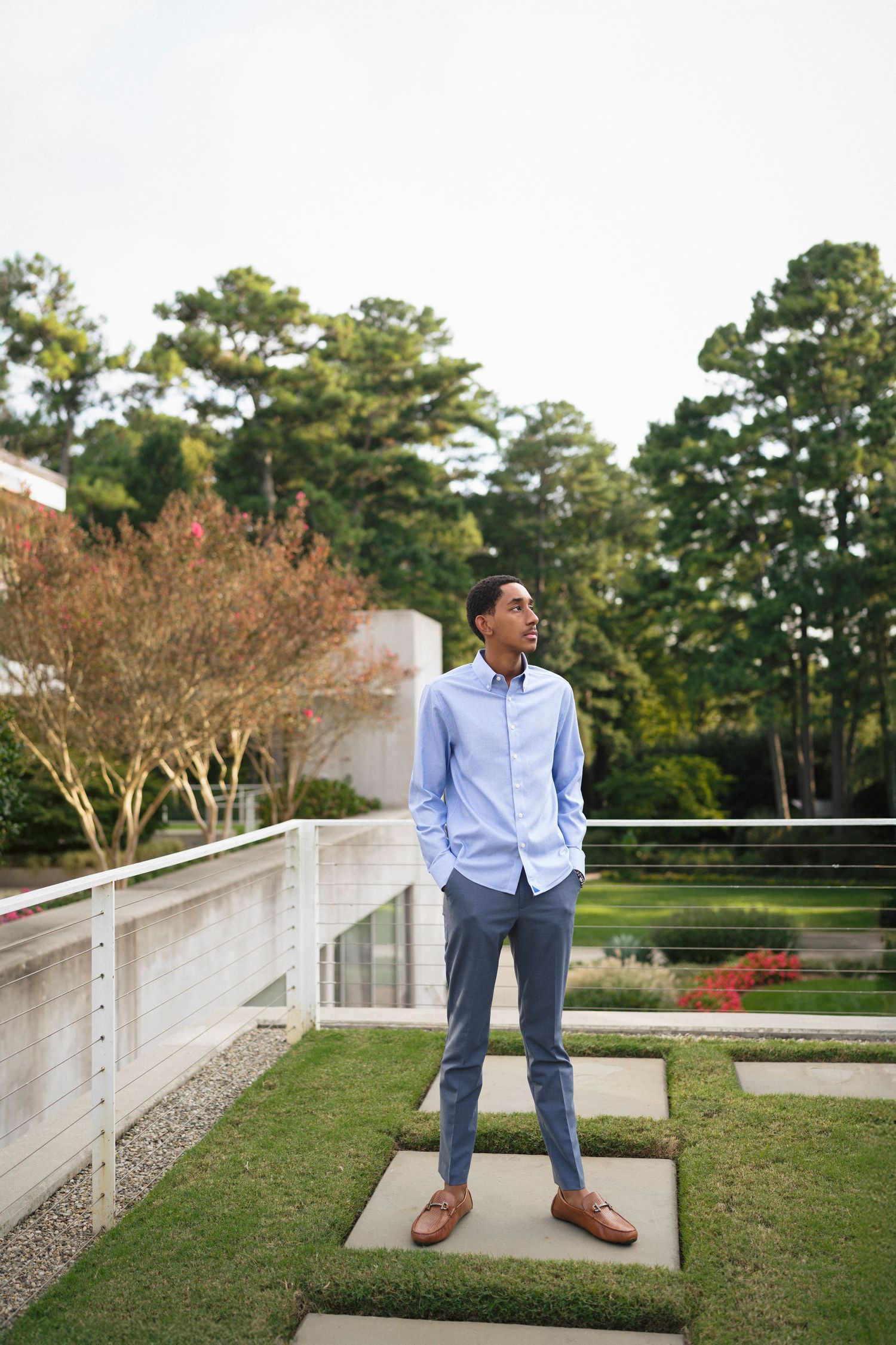 High school senior guy standing on platform at WRAL Azalea Garden in Raleigh, NC