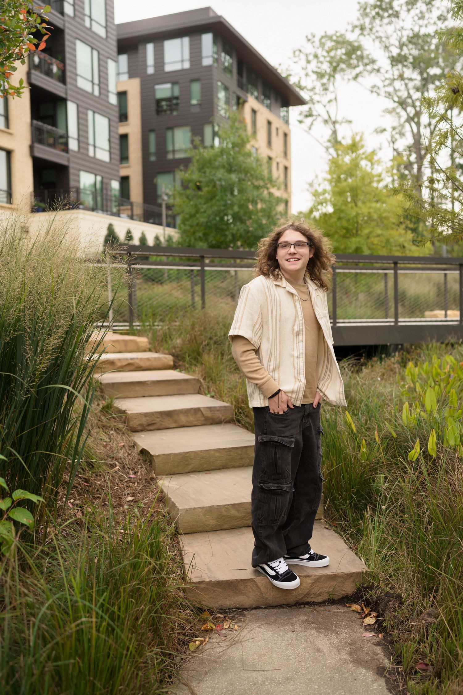 Senior boy laughing during portrait session at Downtown Cary Park in Cary, NC