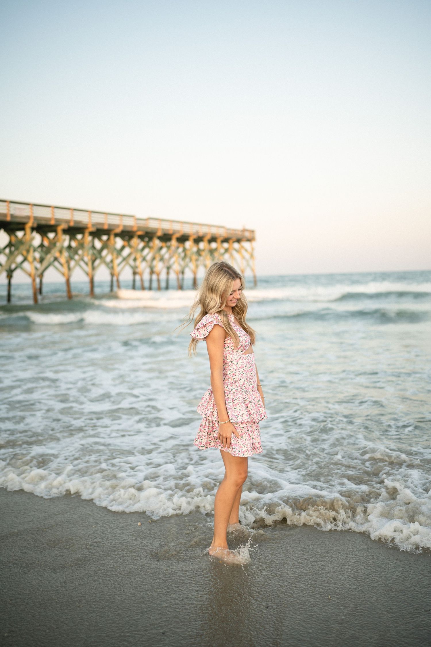 Senior portrait of Sydney at Wilmington, NC pier, showcasing a ocean backdrop during a beachside photo session