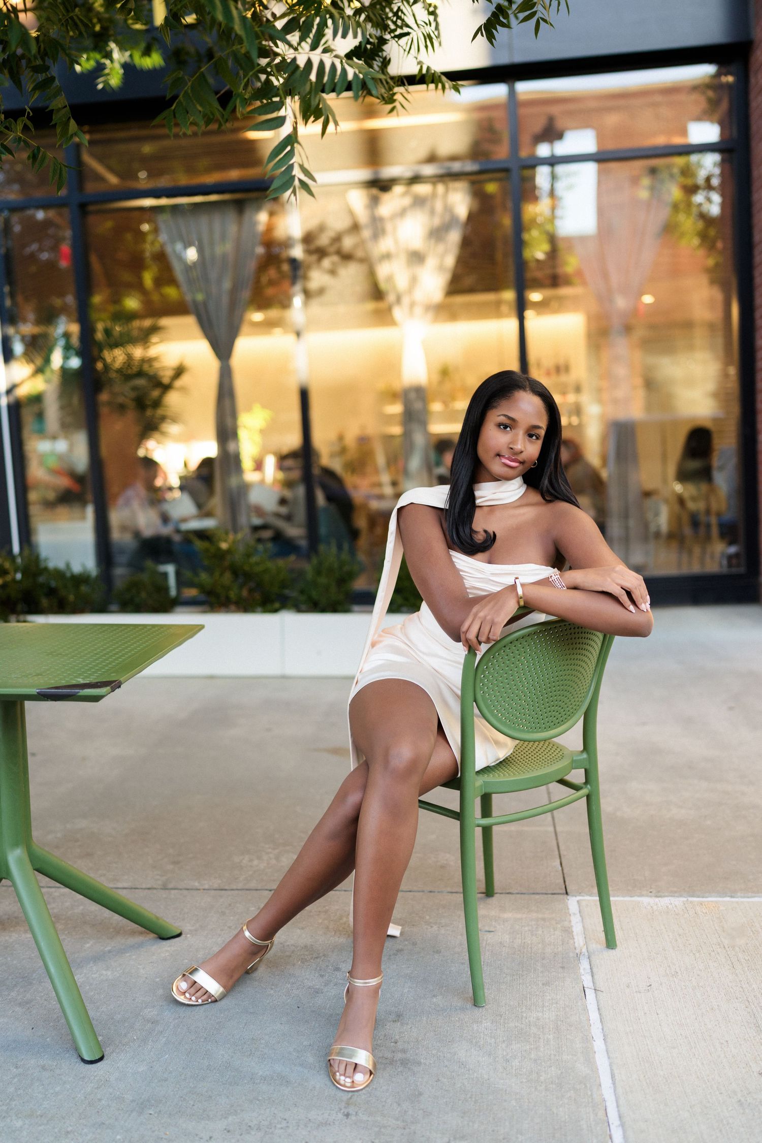 High school senior girl sitting in a chair in an urban setting in the Warehouse District of Raleigh.