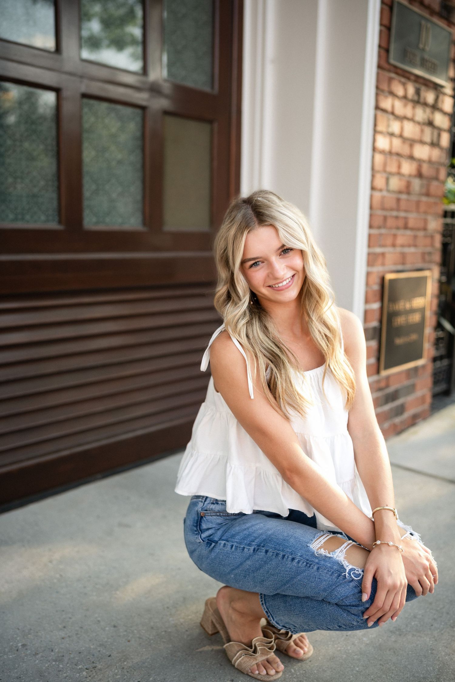 Sydney's senior portrait at a gated home entrance in downtown Wilmington, NC, featuring elegant ironwork and greenery