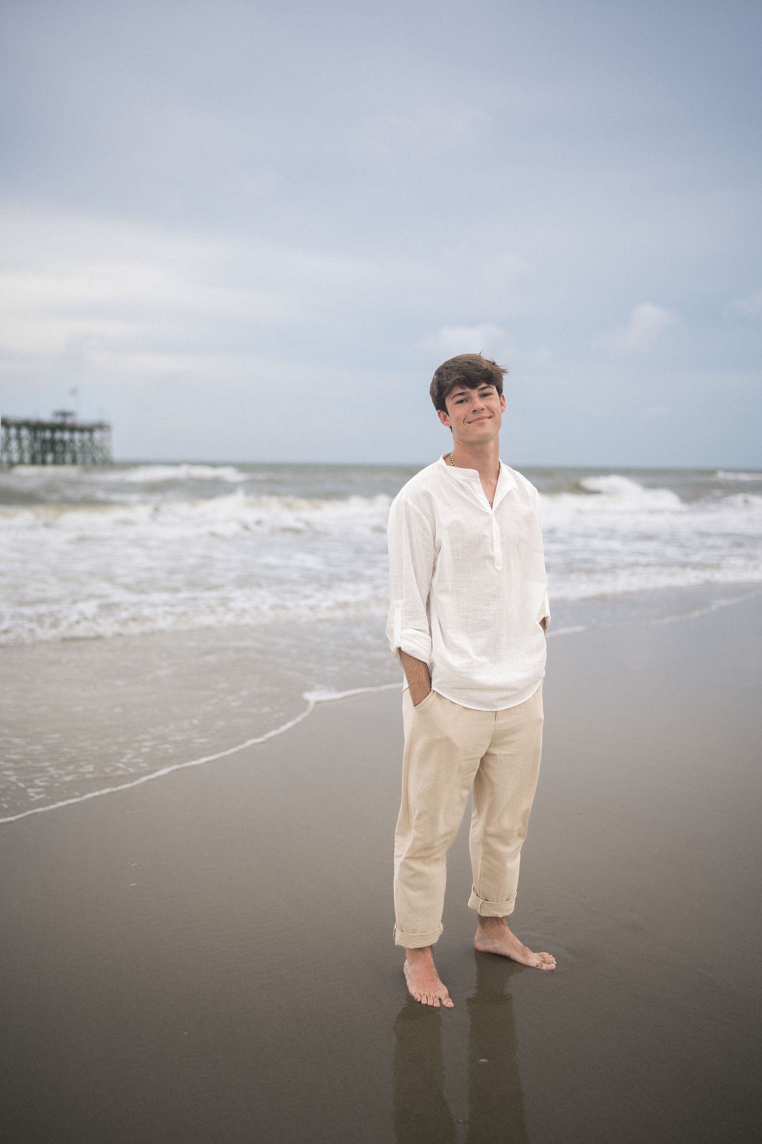 Barefoot high school senior guy portrait on Oak Island Beach in North Carolina