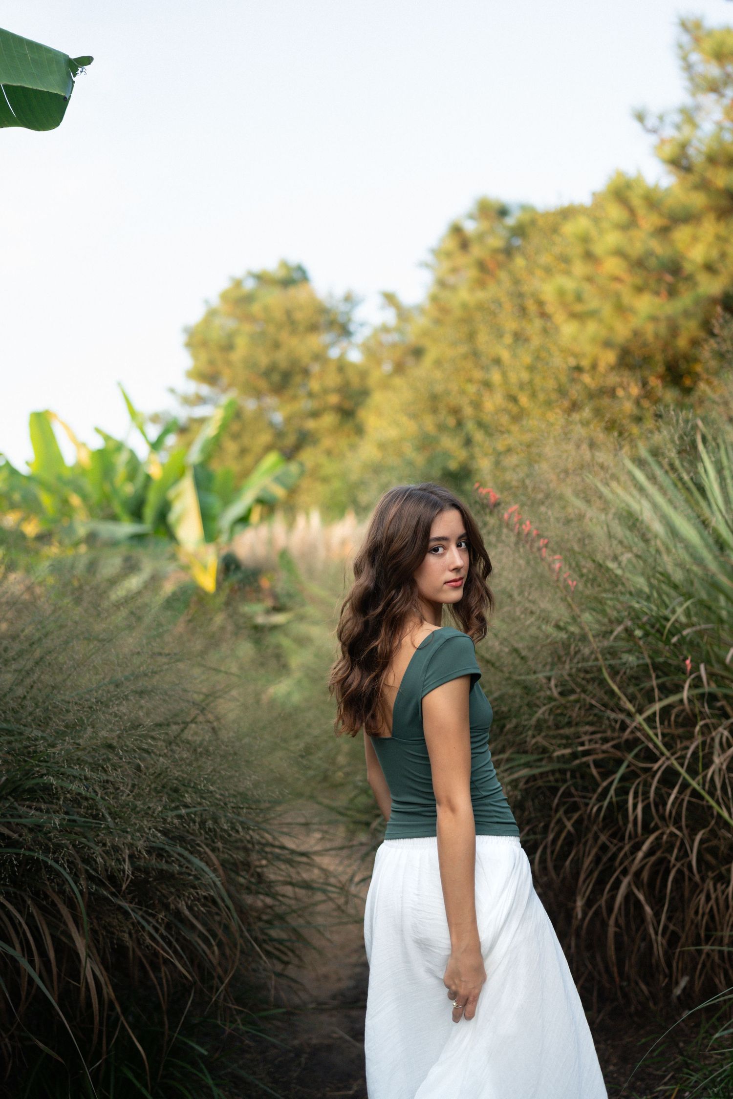 High school senior girl looking back during her session at JC Raulston Arboretum in Raleigh.