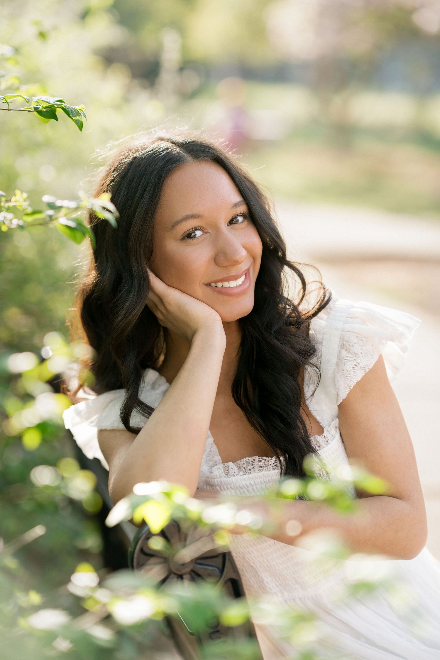 Close-up of a high school senior girl sitting on a bench at Fred Fletcher Park in Raleigh.