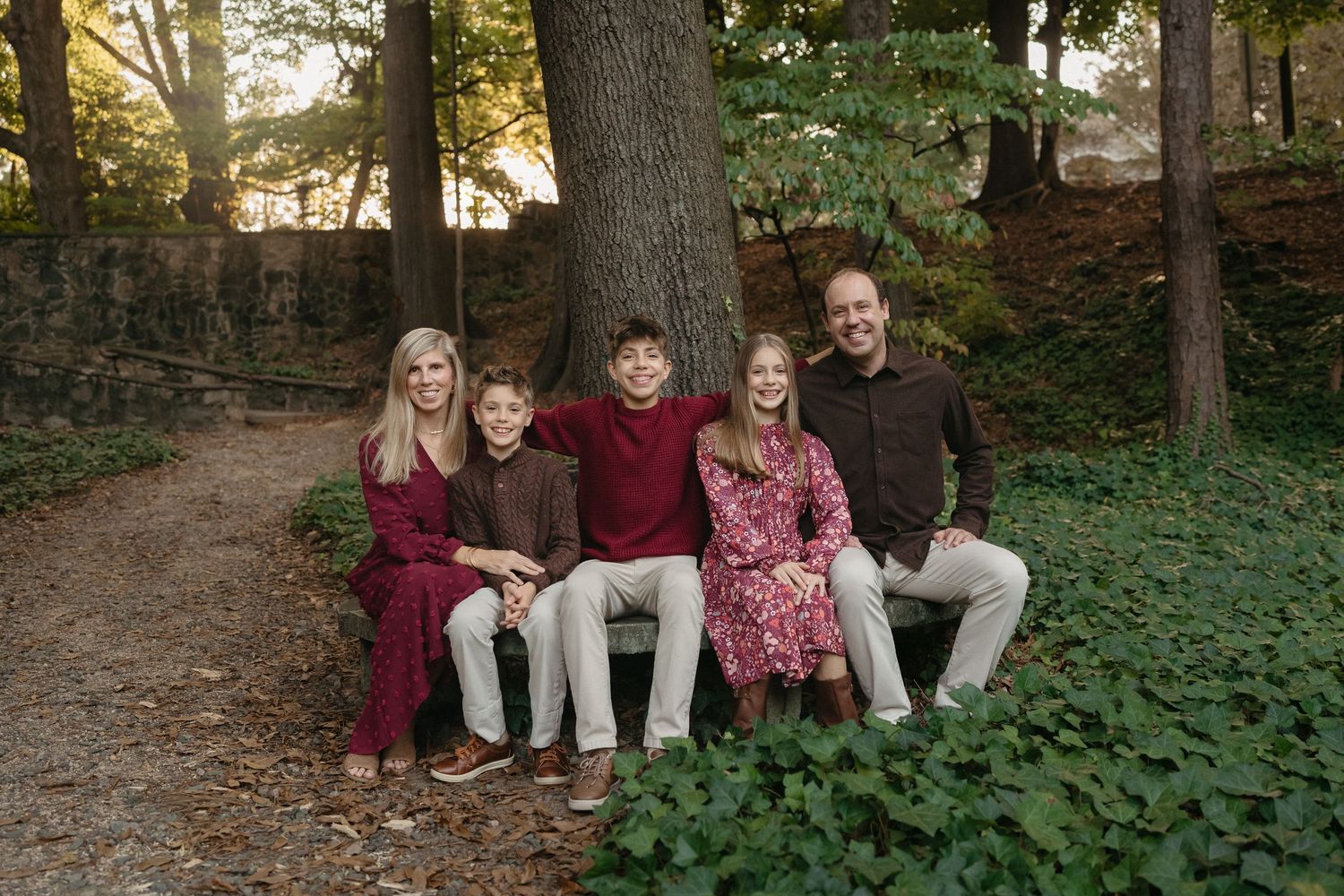 family sitting together  during a mini session at the Raleigh rose garden
