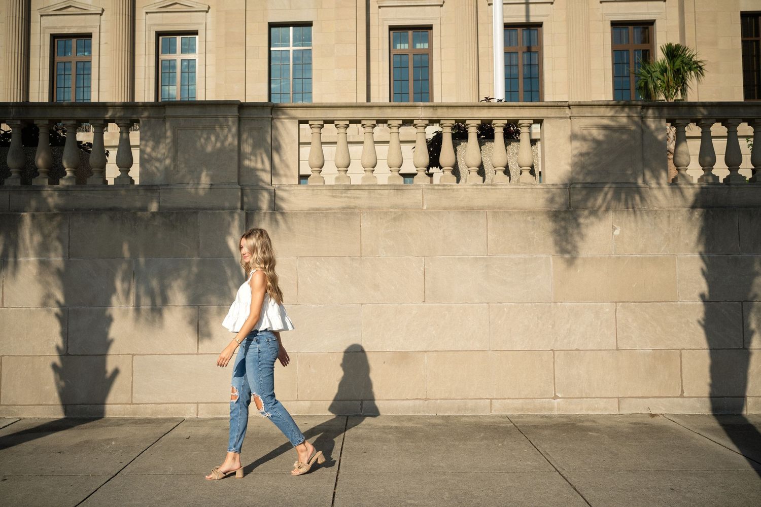 Sydney's senior portrait walking in front of the Alton Lennon Federal Building downtown Wilmington, NC