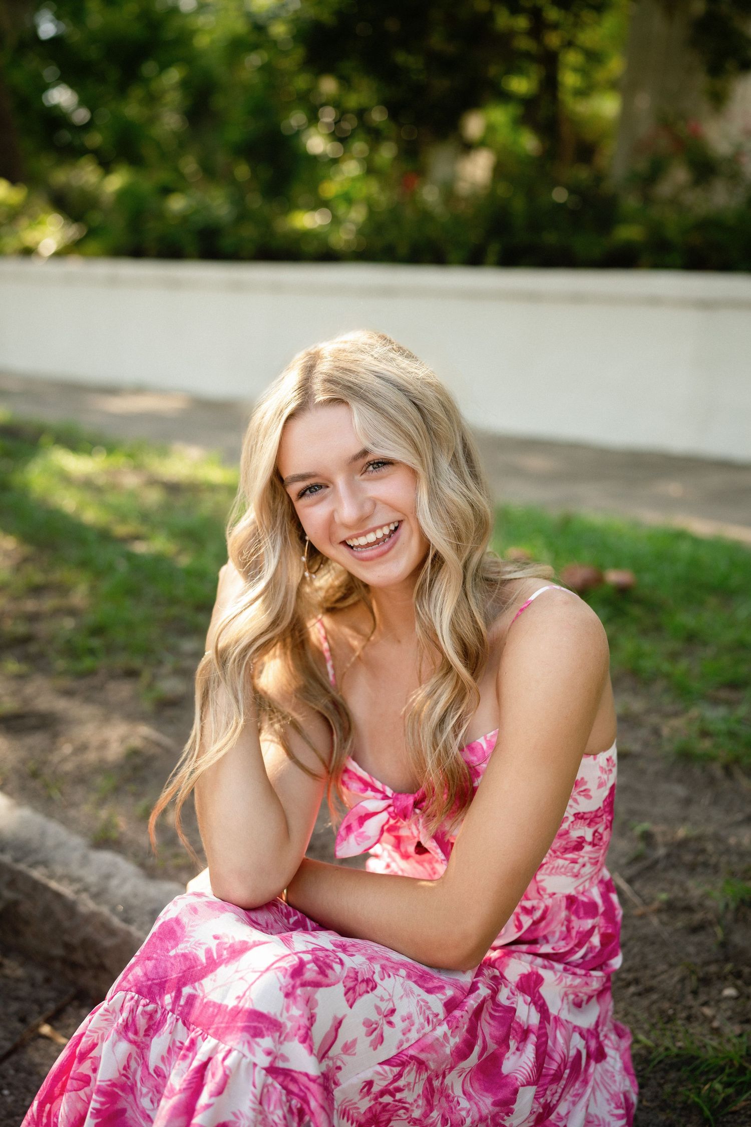 Senior photo of Sydney sitting on a curb in Wilmington, NC