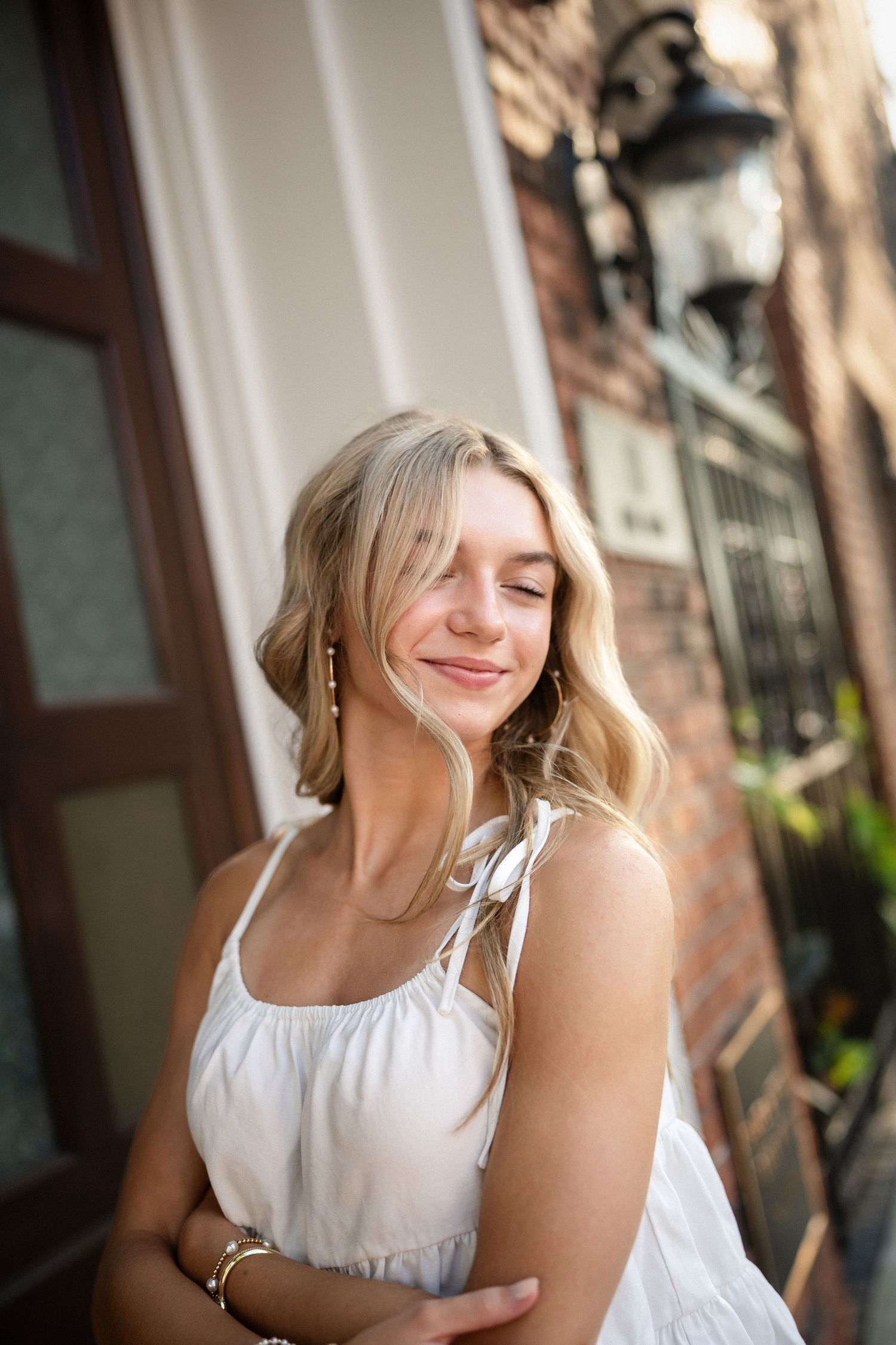 Sydney's senior portrait at a gated home entrance in downtown Wilmington, NC, featuring elegant ironwork and greenery