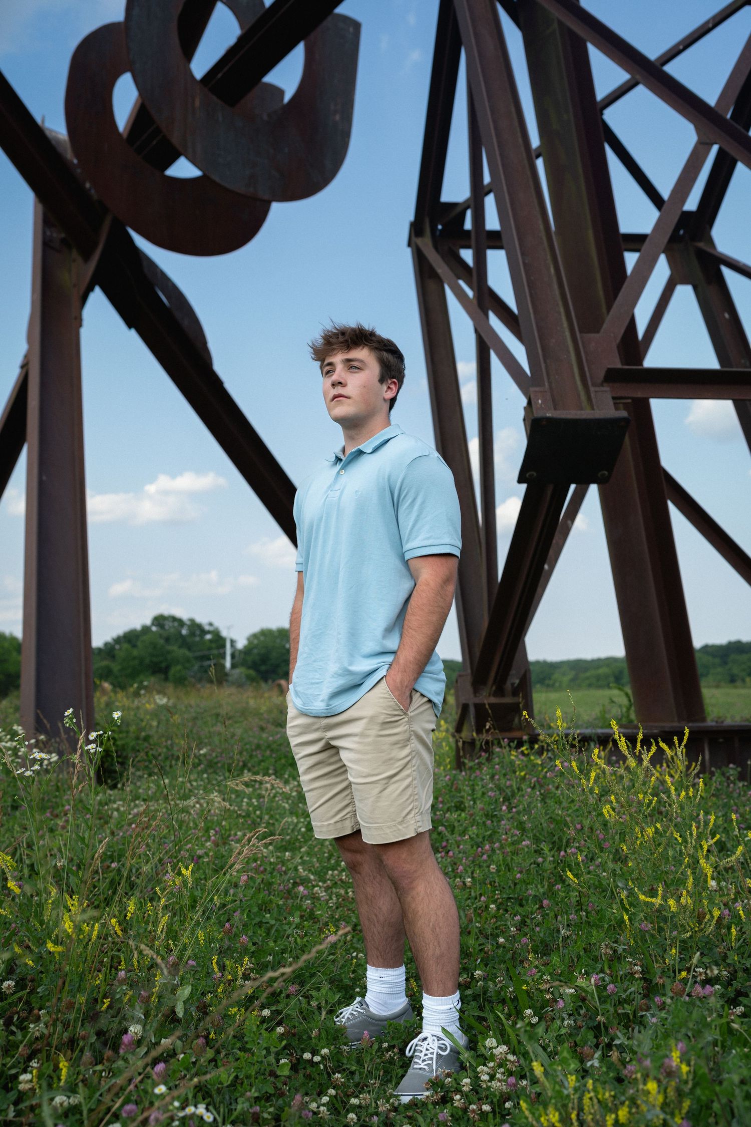 High school senior guy photographed near sculpture at NC Museum of Art in Raleigh, NC