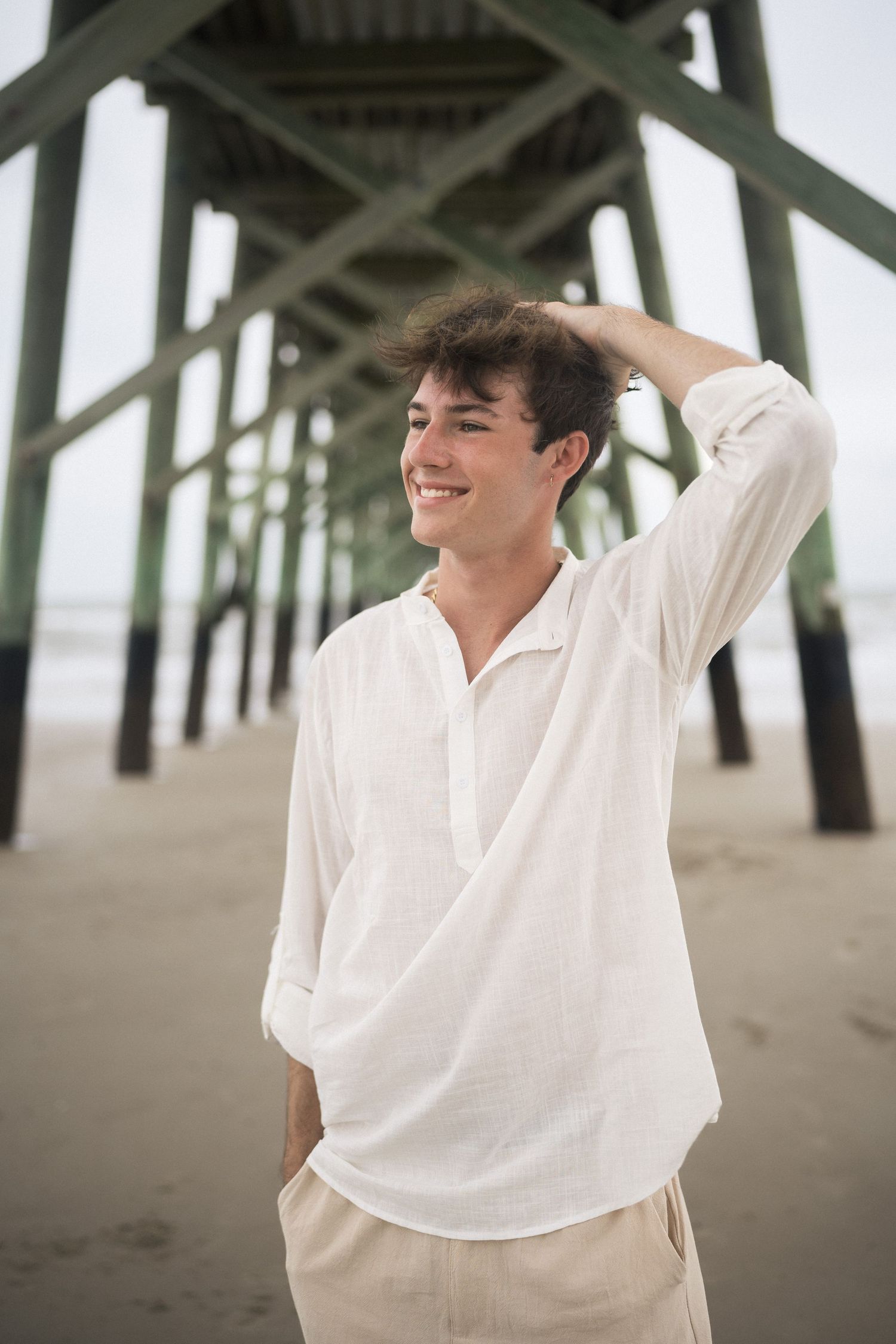 Senior boy portrait at Oak Island pier during beach session