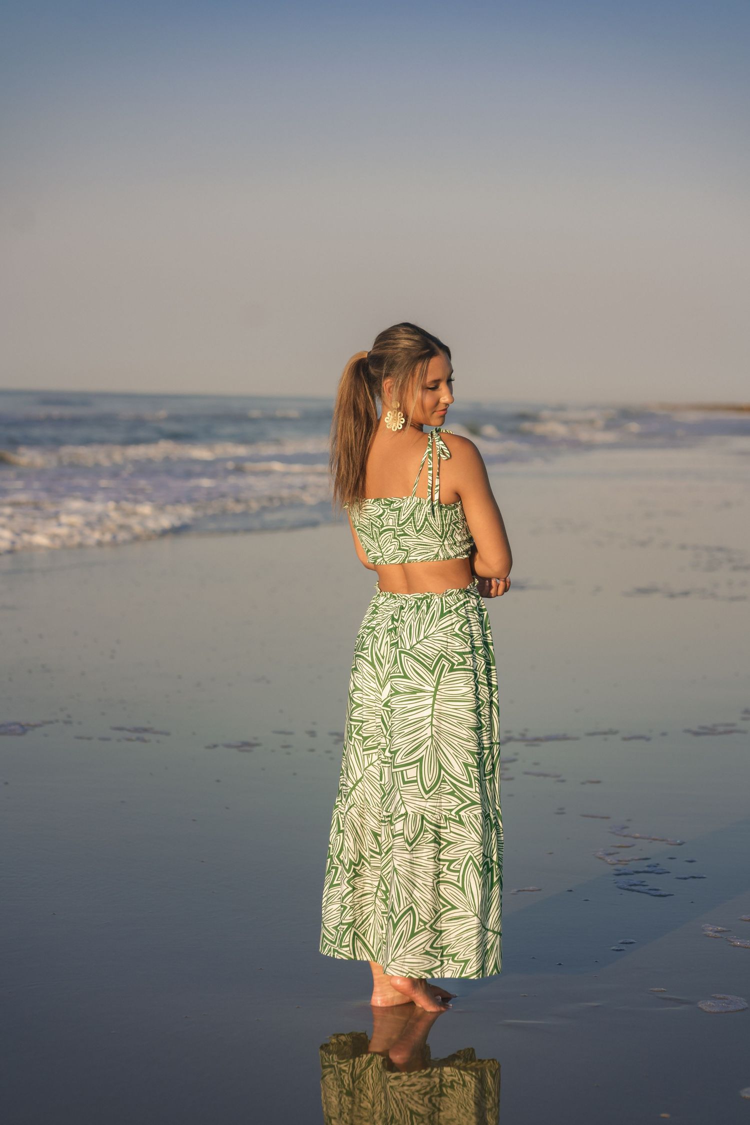 Sunrise senior photo at Folly Beach in a soft green floral two-piece maxi outfit.