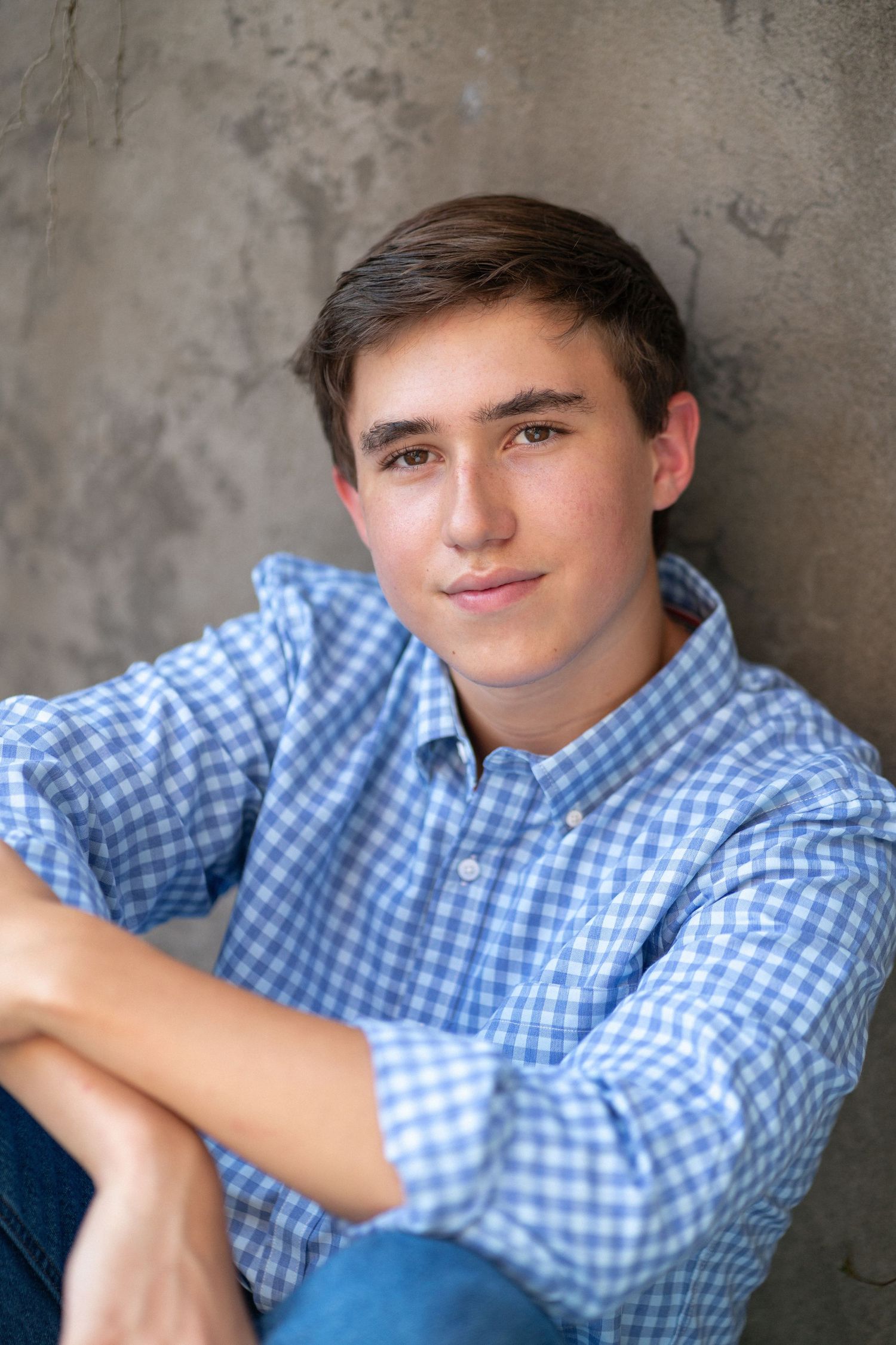 Close-up portrait smiling in a blue checkered shirt at NCMA senior session.