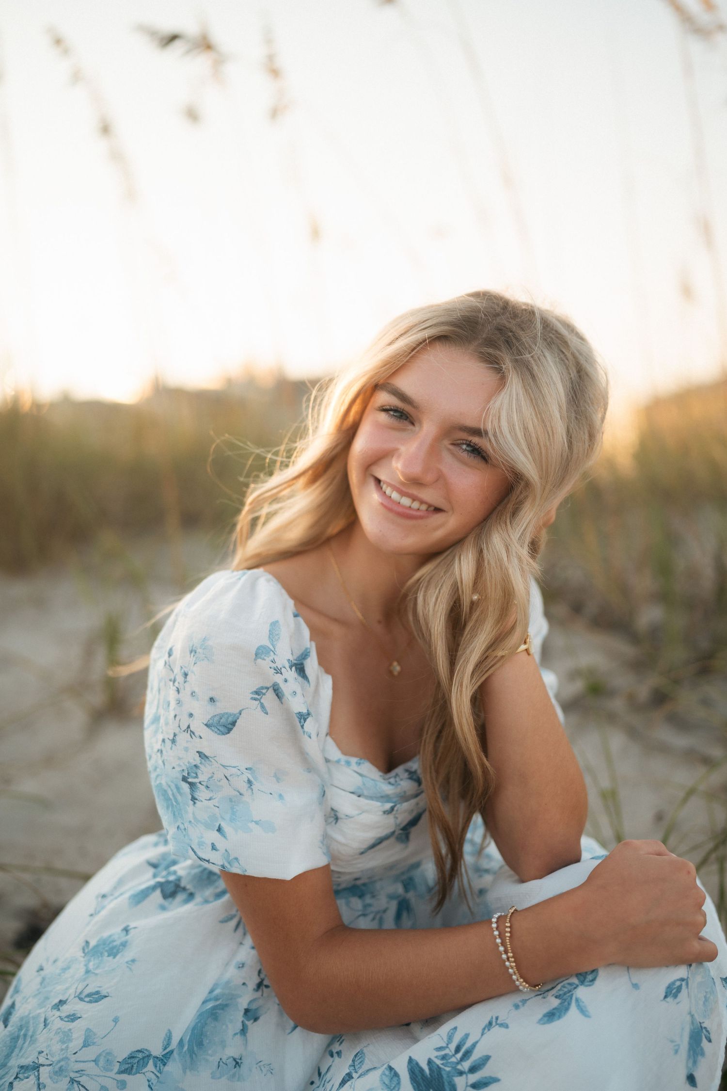 High school senior girl posing on the beach during her senior photo session at Wrightsville Beach, North Carolina.