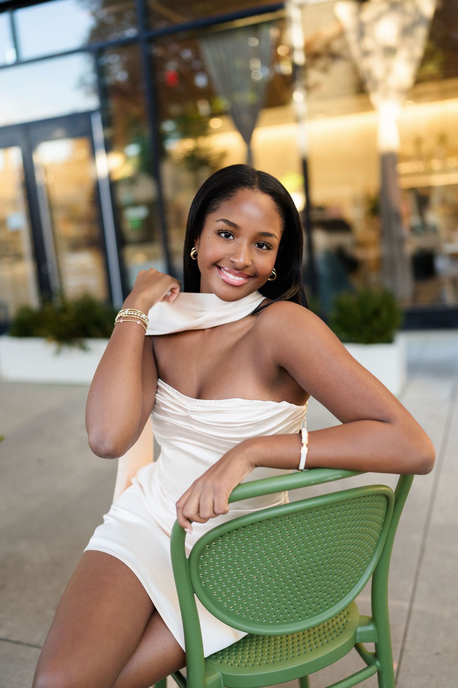 High school senior girl posing in a chair in downtown Raleigh’s Warehouse District during her senior session.