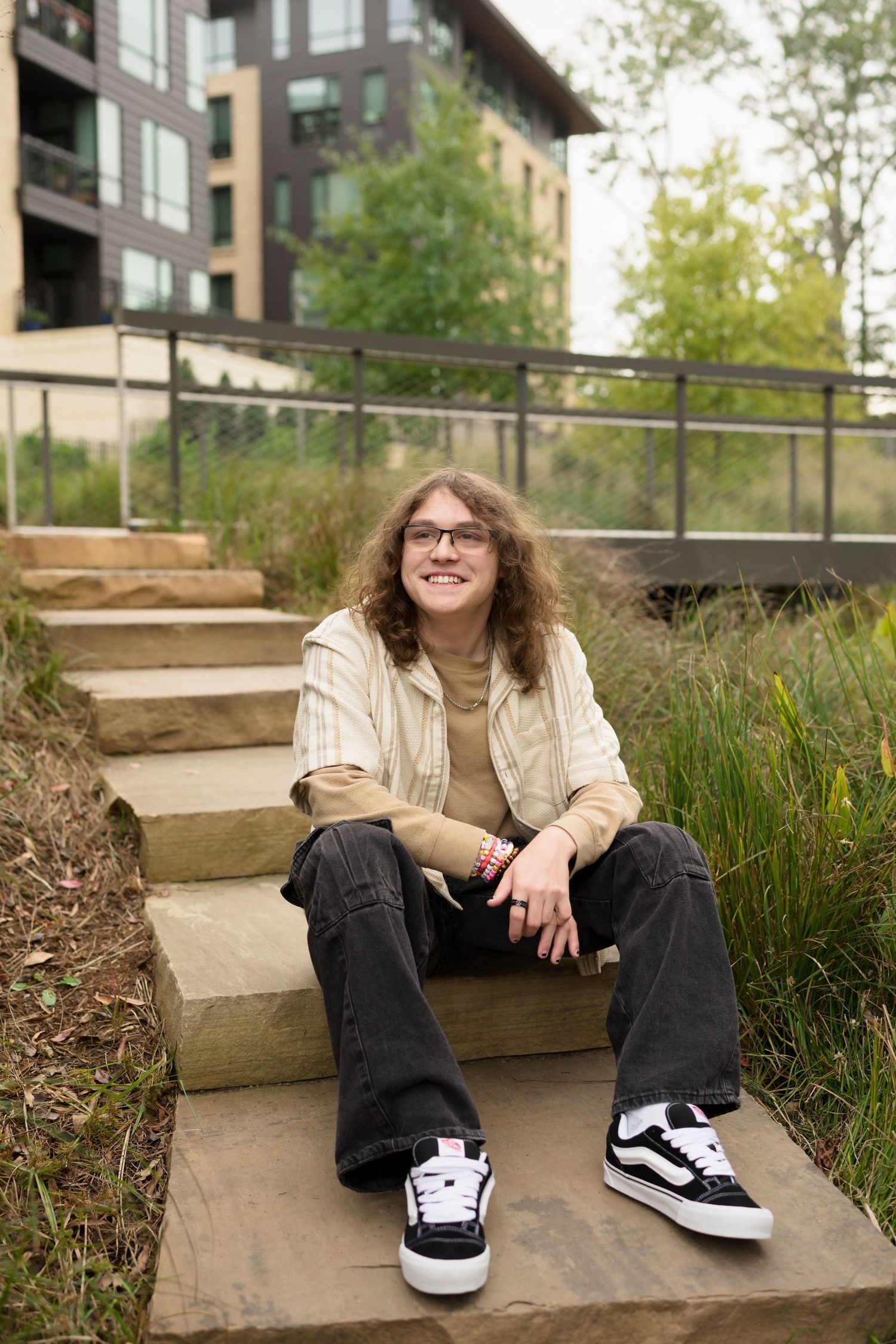 High school senior guy in black jeans and Vans photographed at Downtown Cary Park