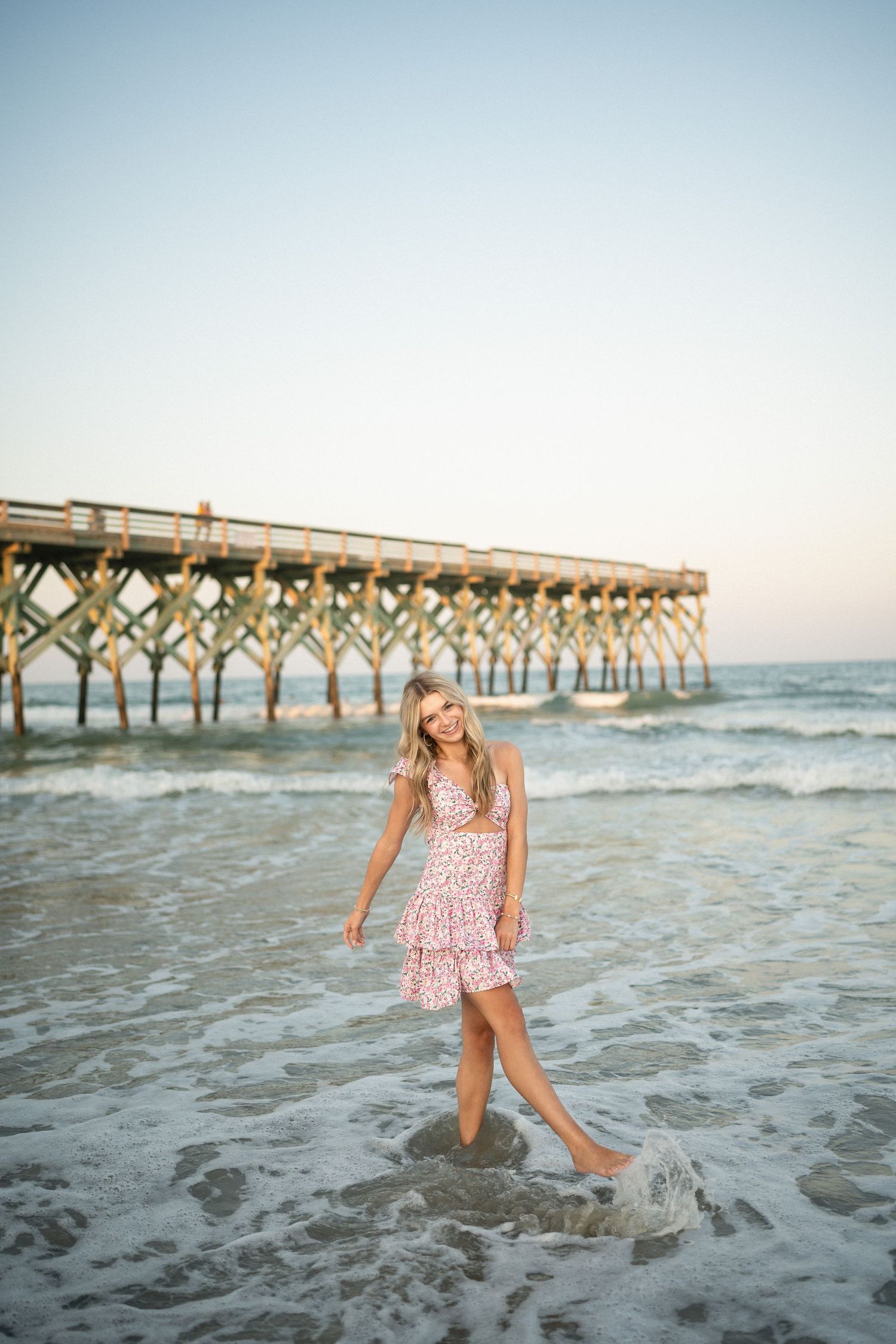 Senior portrait of Sydney at Wilmington, NC pier, showcasing a ocean backdrop during a beachside photo session