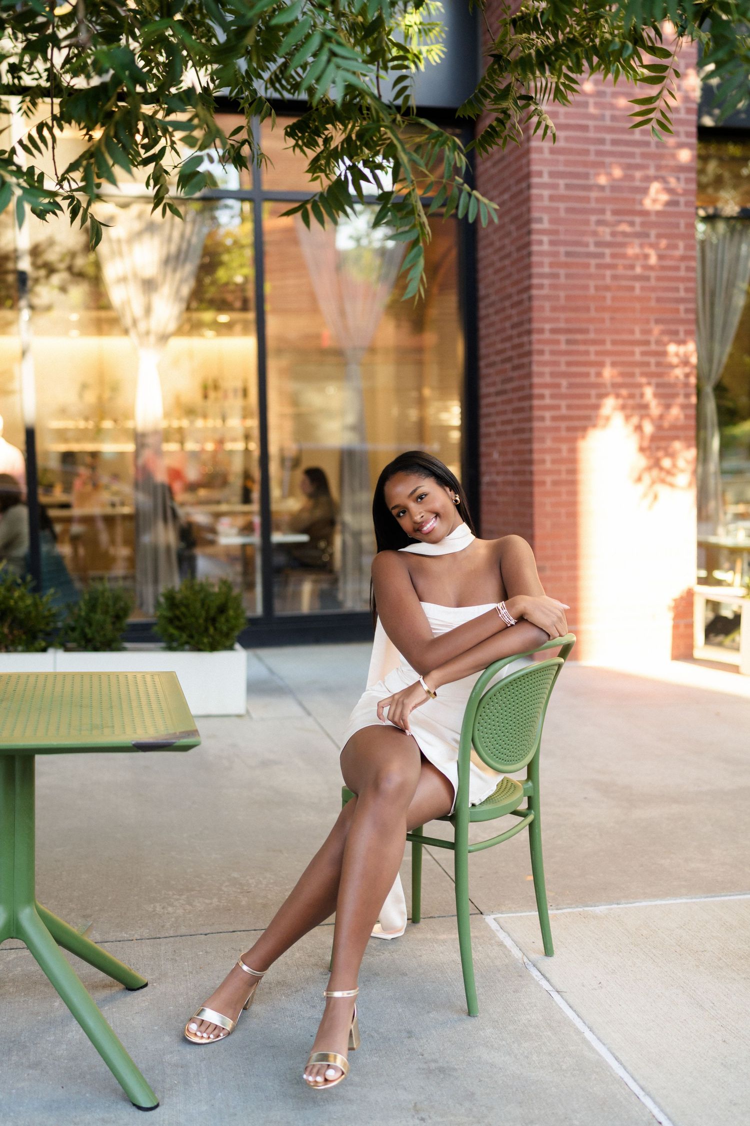 High school senior girl sitting in a chair during her senior photo session in the Warehouse District of Raleigh, North Carolina.
