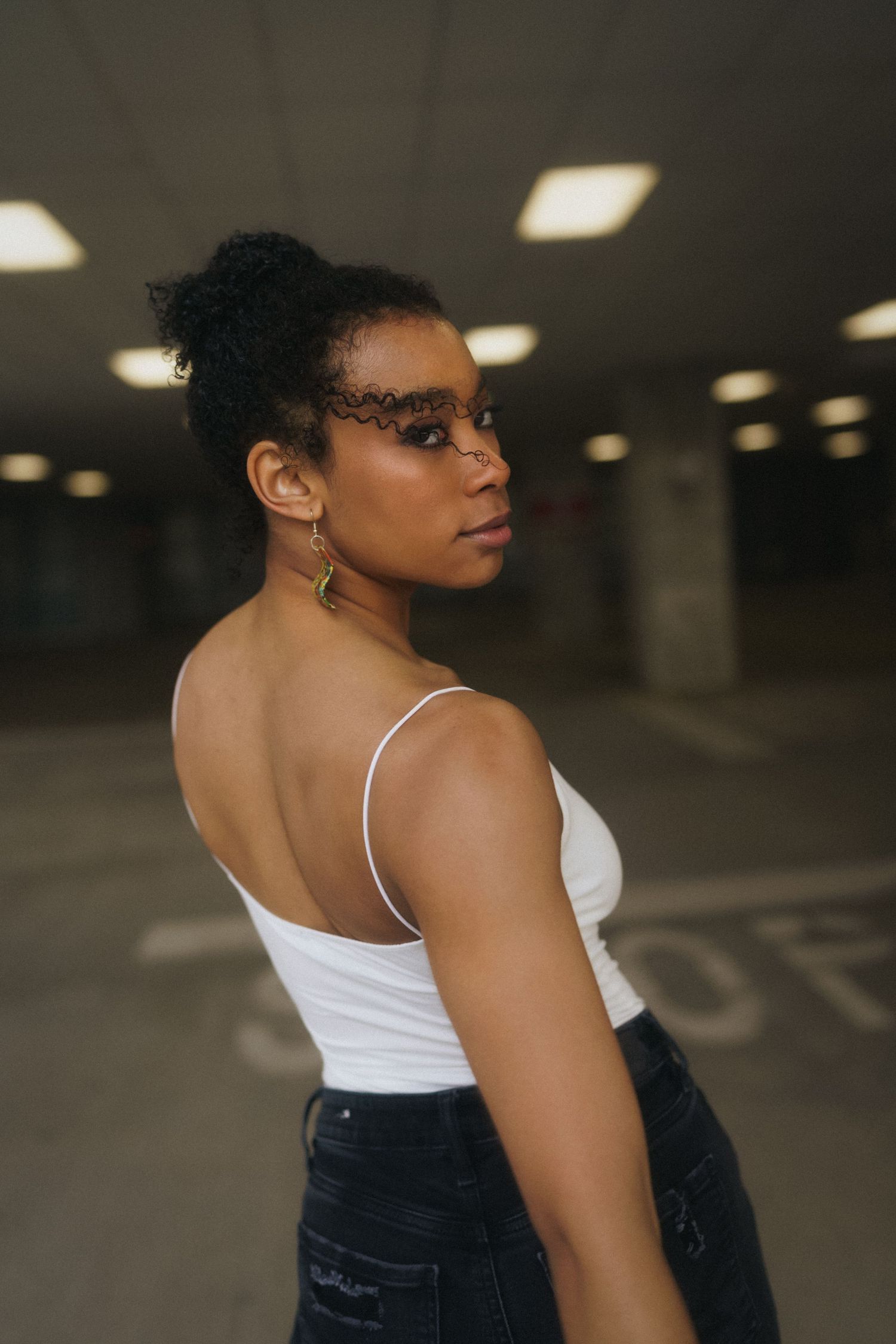 Close-up of a high school senior girl looking over her shoulder on a parking deck in downtown Raleigh.