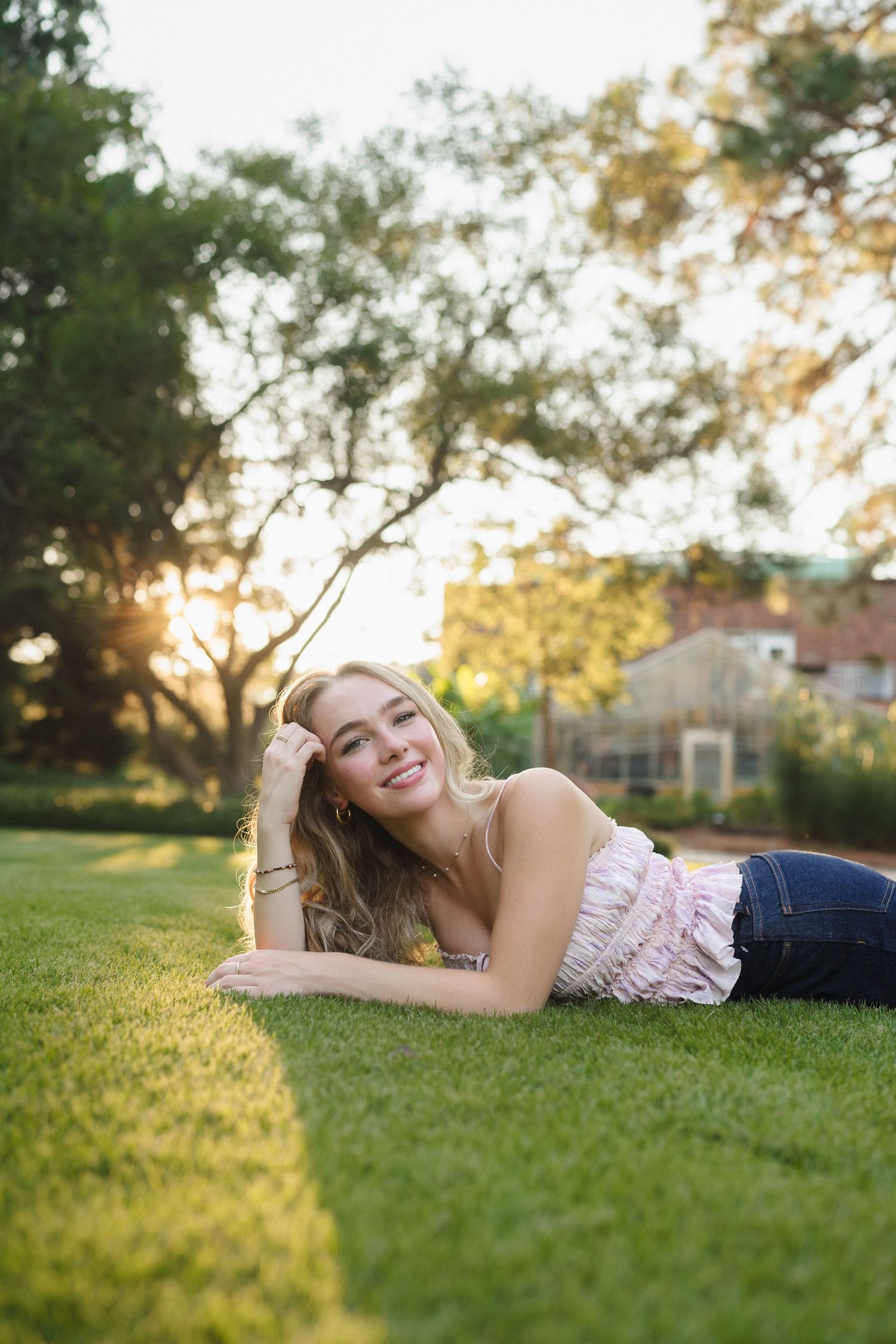 High school senior girl laying in the grass at Sandhills Horticultural Gardens in Pinehurst, North Carolina.