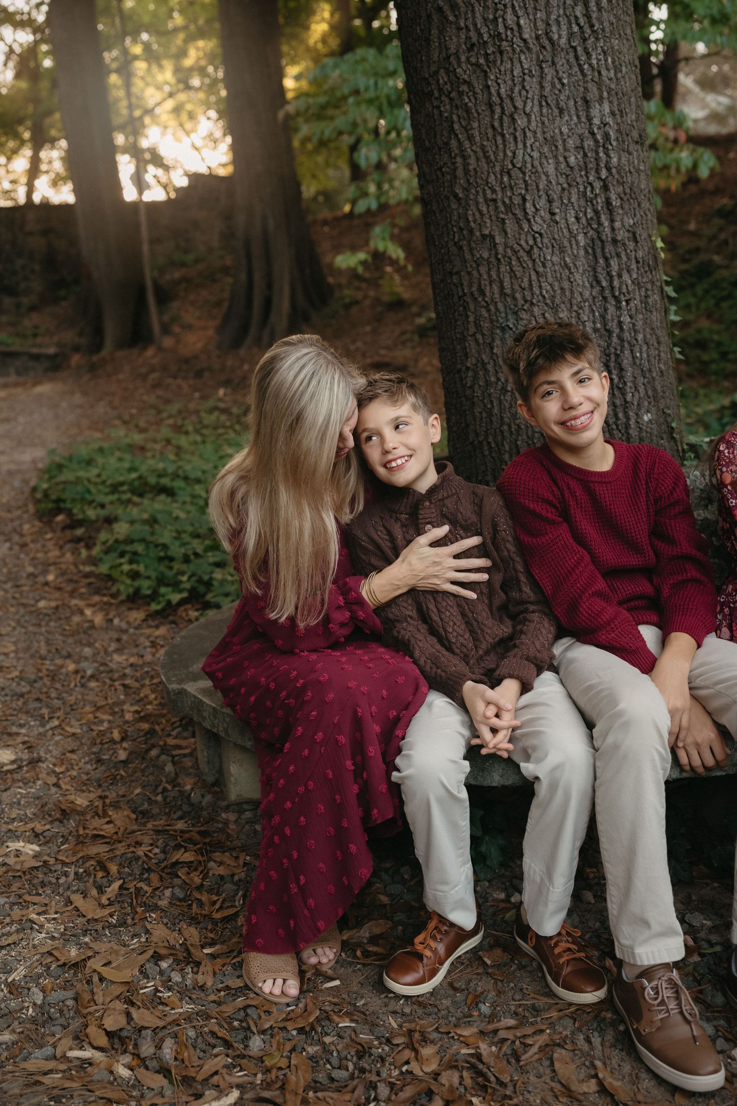 Young child smiling while being held by a parent during a family photo session at the Raleigh rose garden