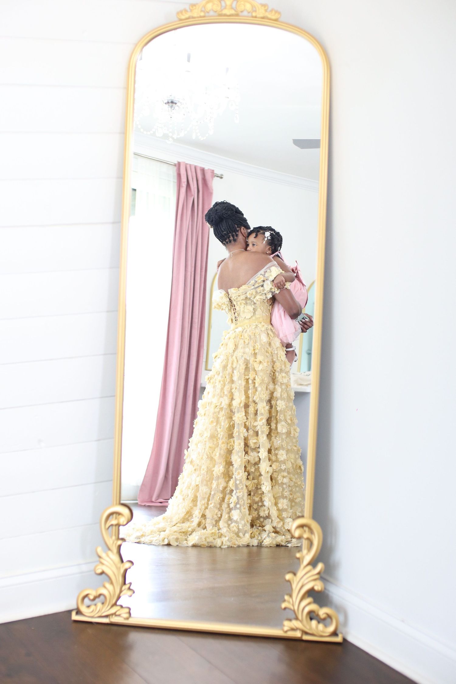 Mirror reflection showing an elegant yellow lace gown in an ornate gold frame.