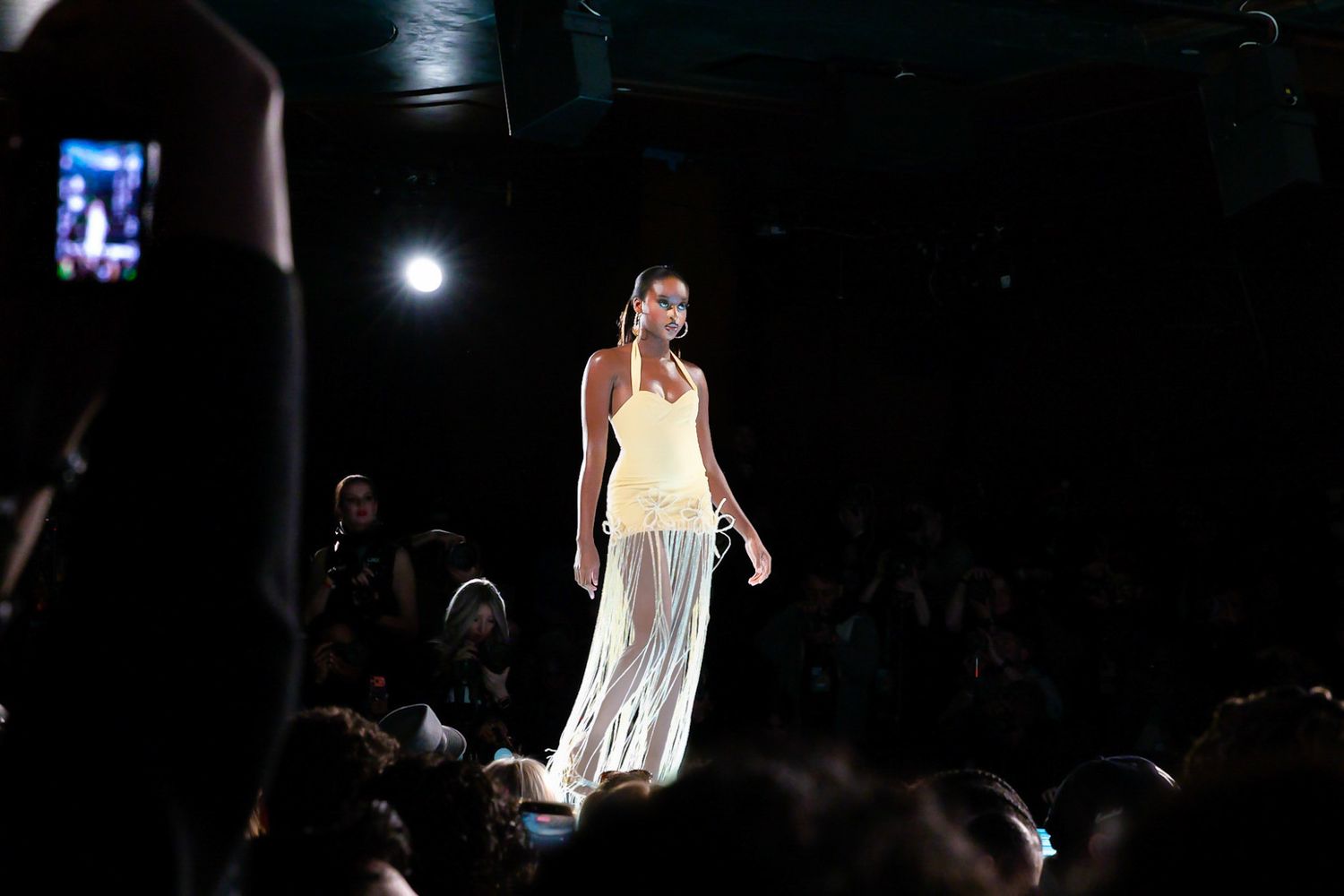 Models walk the runway in white slip dresses during a fashion show presentation.