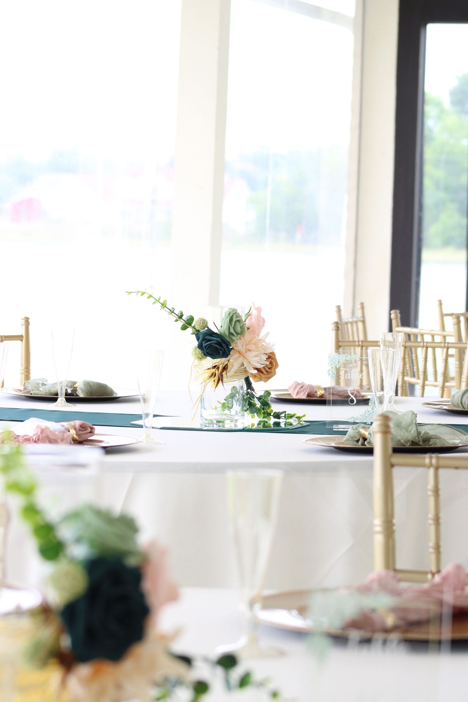 Wedding reception table set with white linens and delicate floral centerpieces.