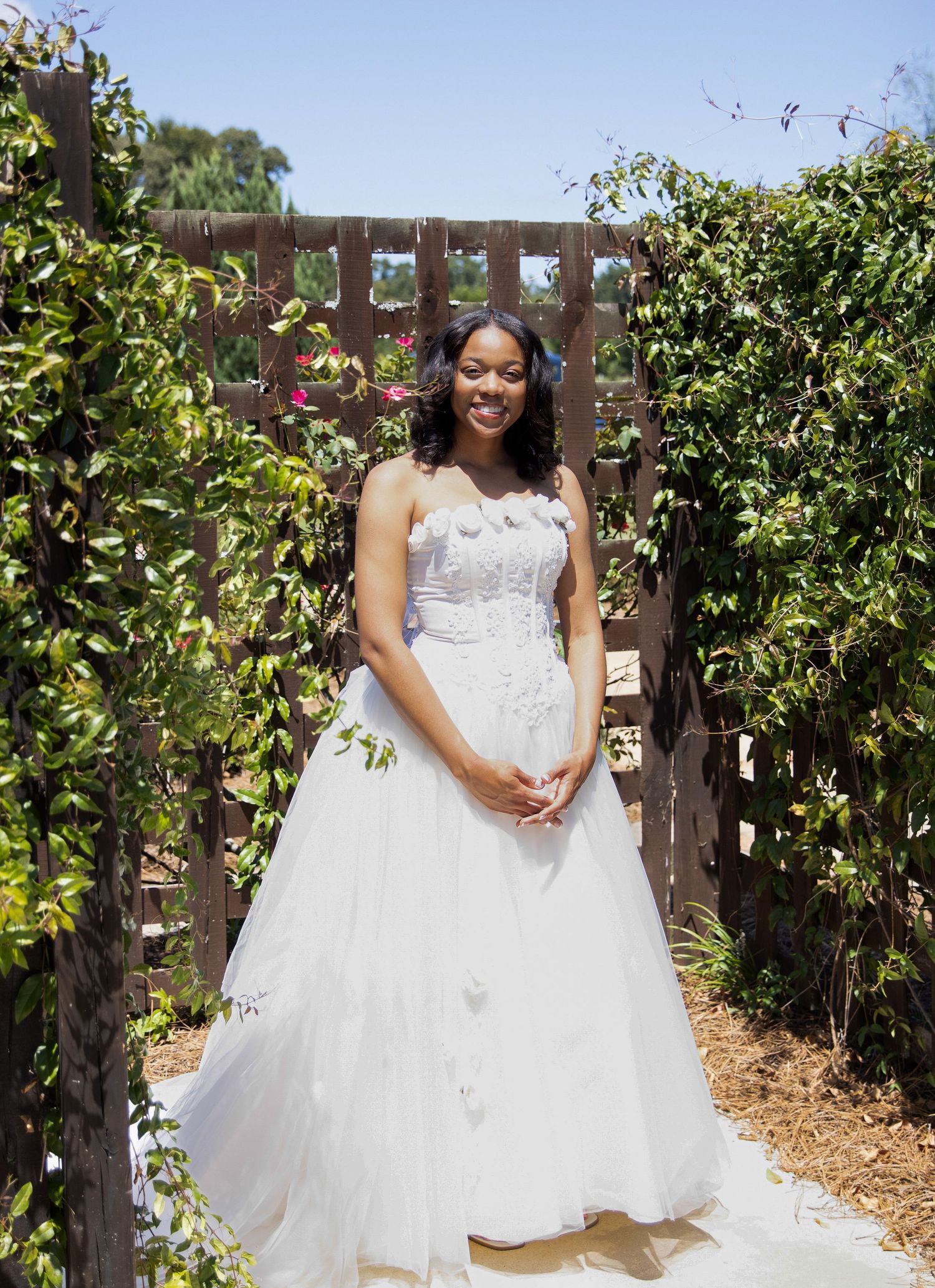A classic bridal portrait set among vines and wooden fencing on a sunny day.