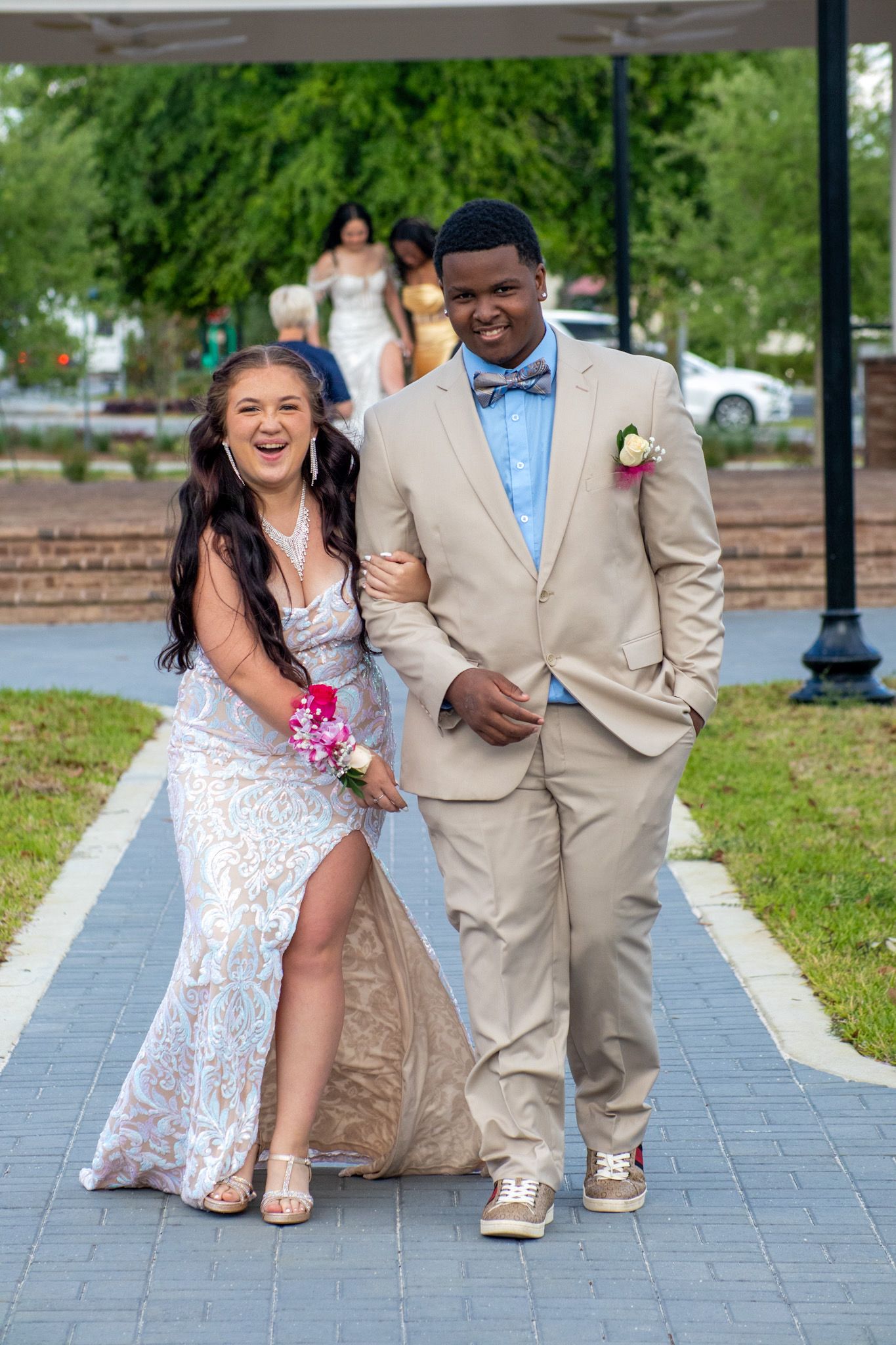 Fun outdoor wedding photos showing playful poses on a brick pathway.