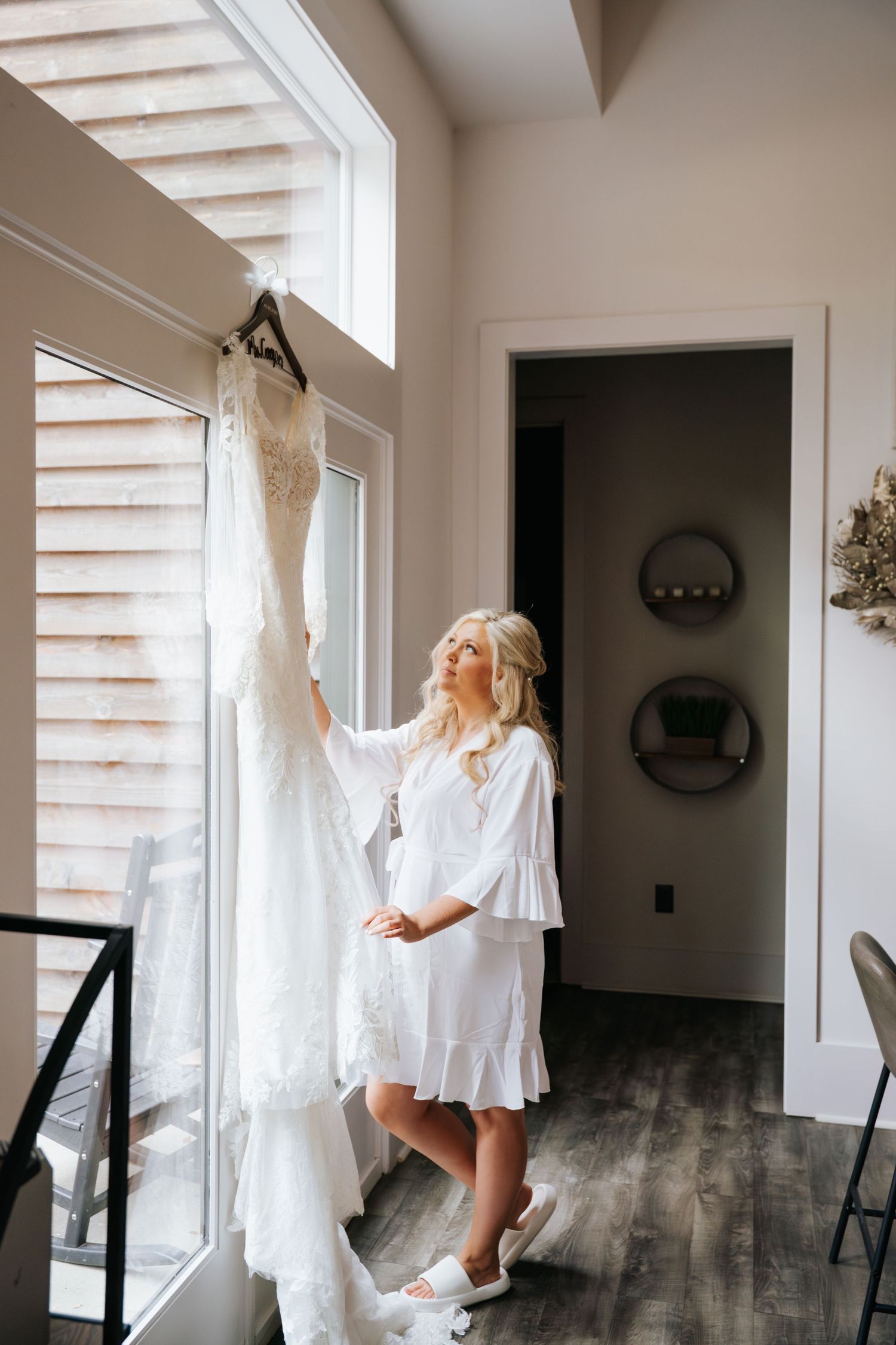 White flowy dress twirls gracefully against sunlit windows in a modern interior space.