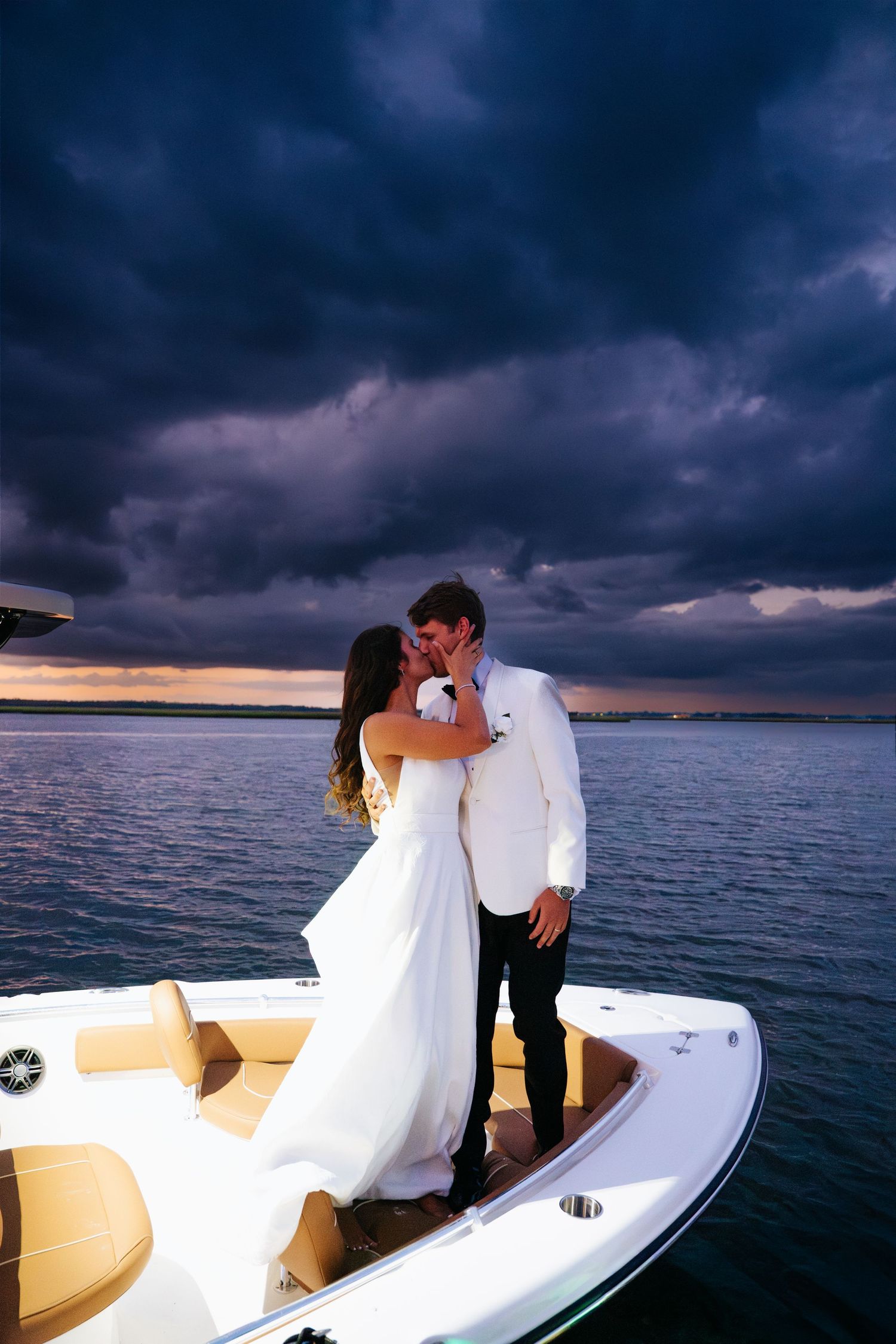 Romantic moment captured on a boat at sunset with dramatic storm clouds overhead.