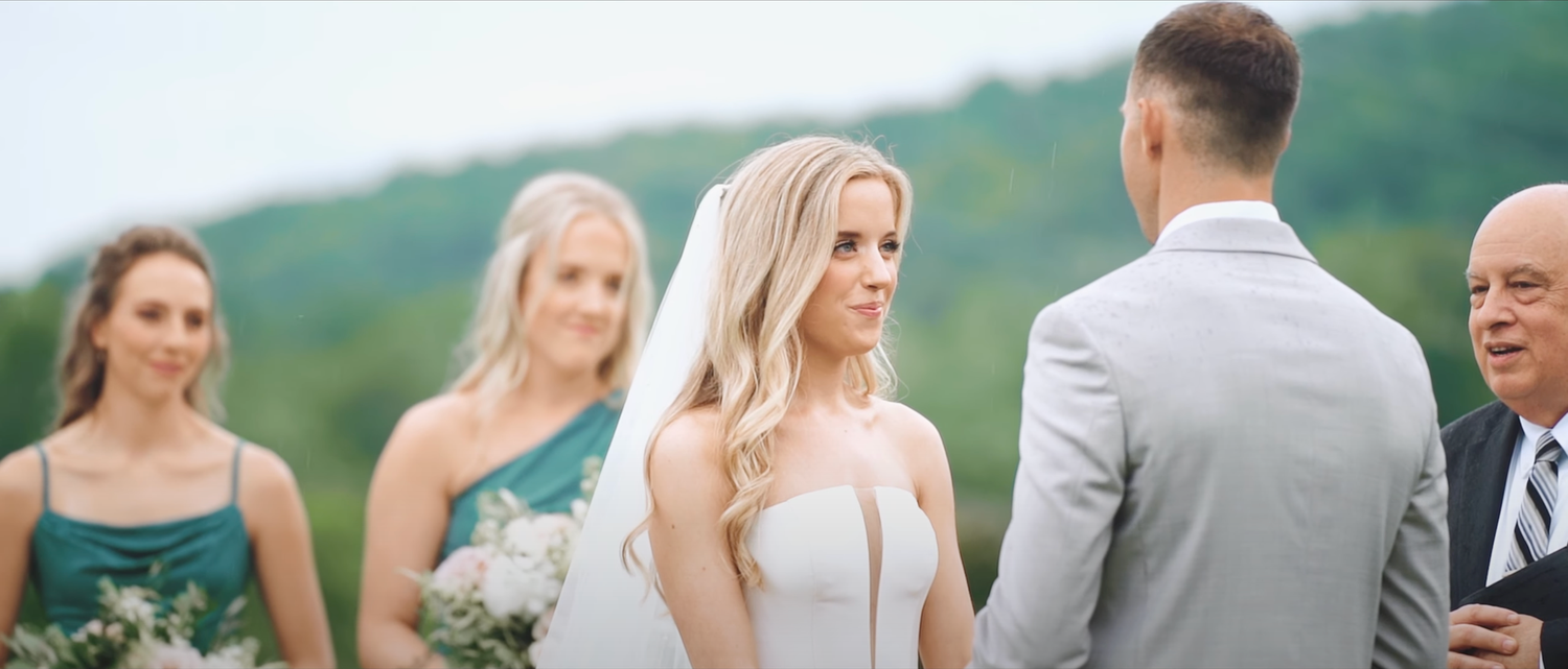 Wedding party celebrates on a scenic hilltop during golden hour.