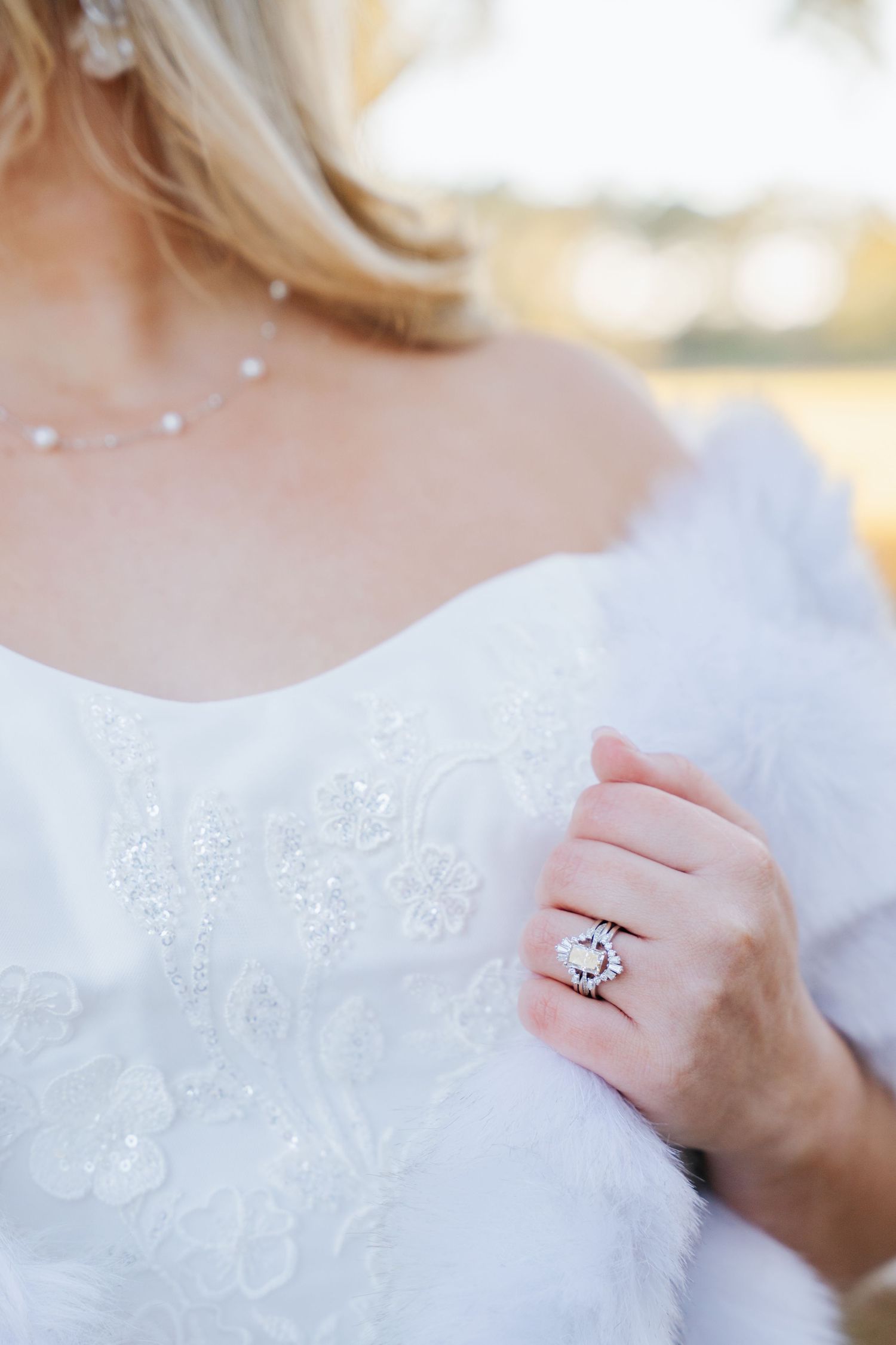 Close-up detail shots of a white lace wedding dress and diamond engagement ring.