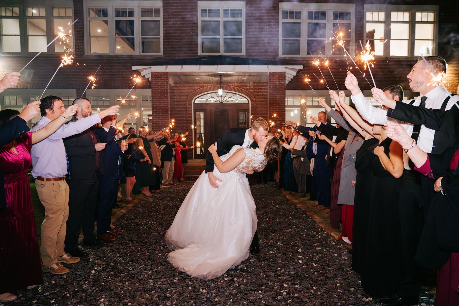 Wedding reception dance floor filled with celebrating guests in evening venue.