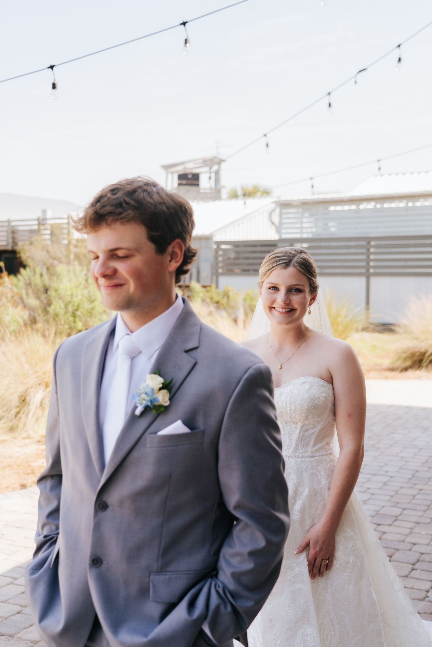 Wedding couple sharing a romantic moment outdoors under string lights.