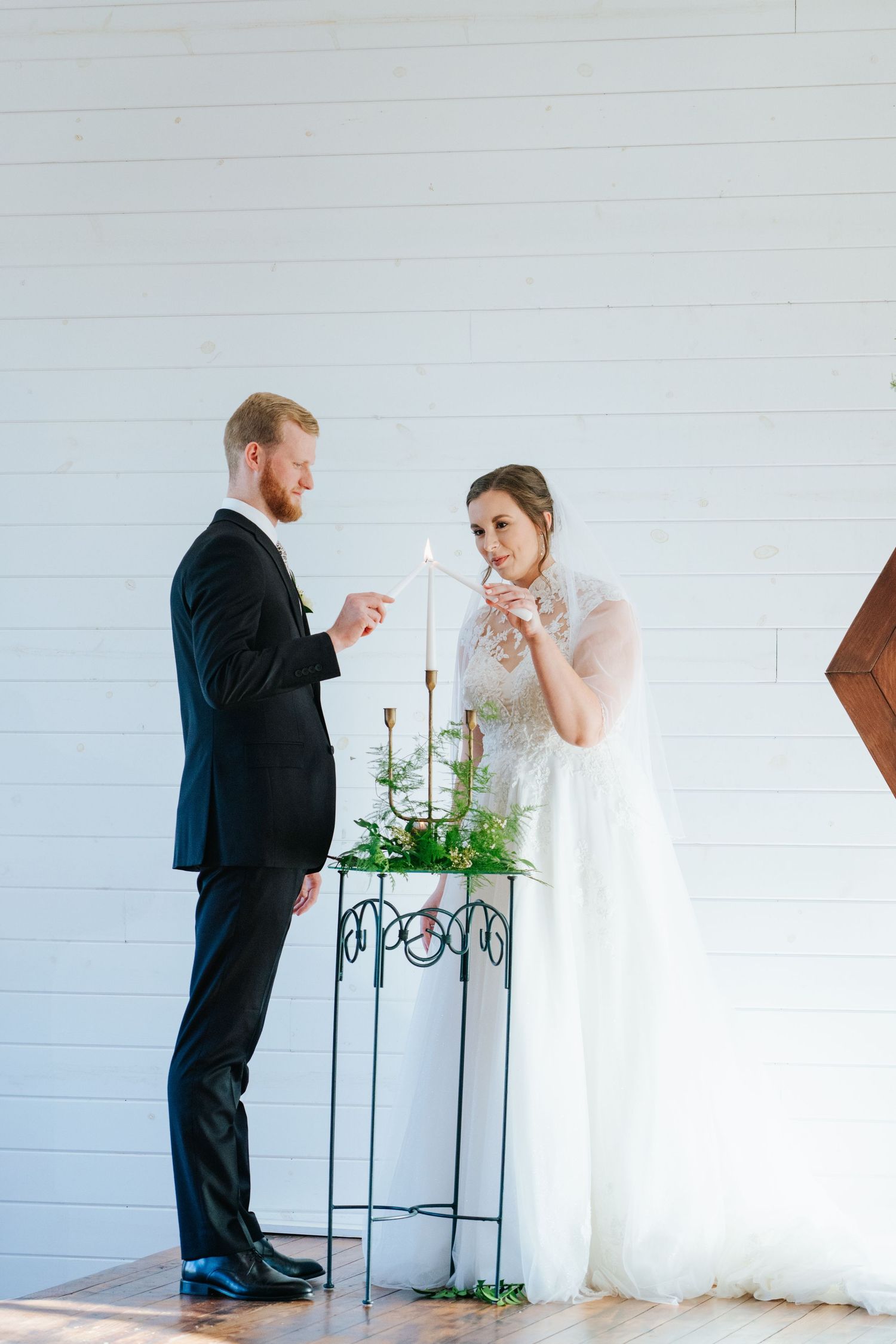 First look wedding moment captured in a bright white room with minimal decor.
