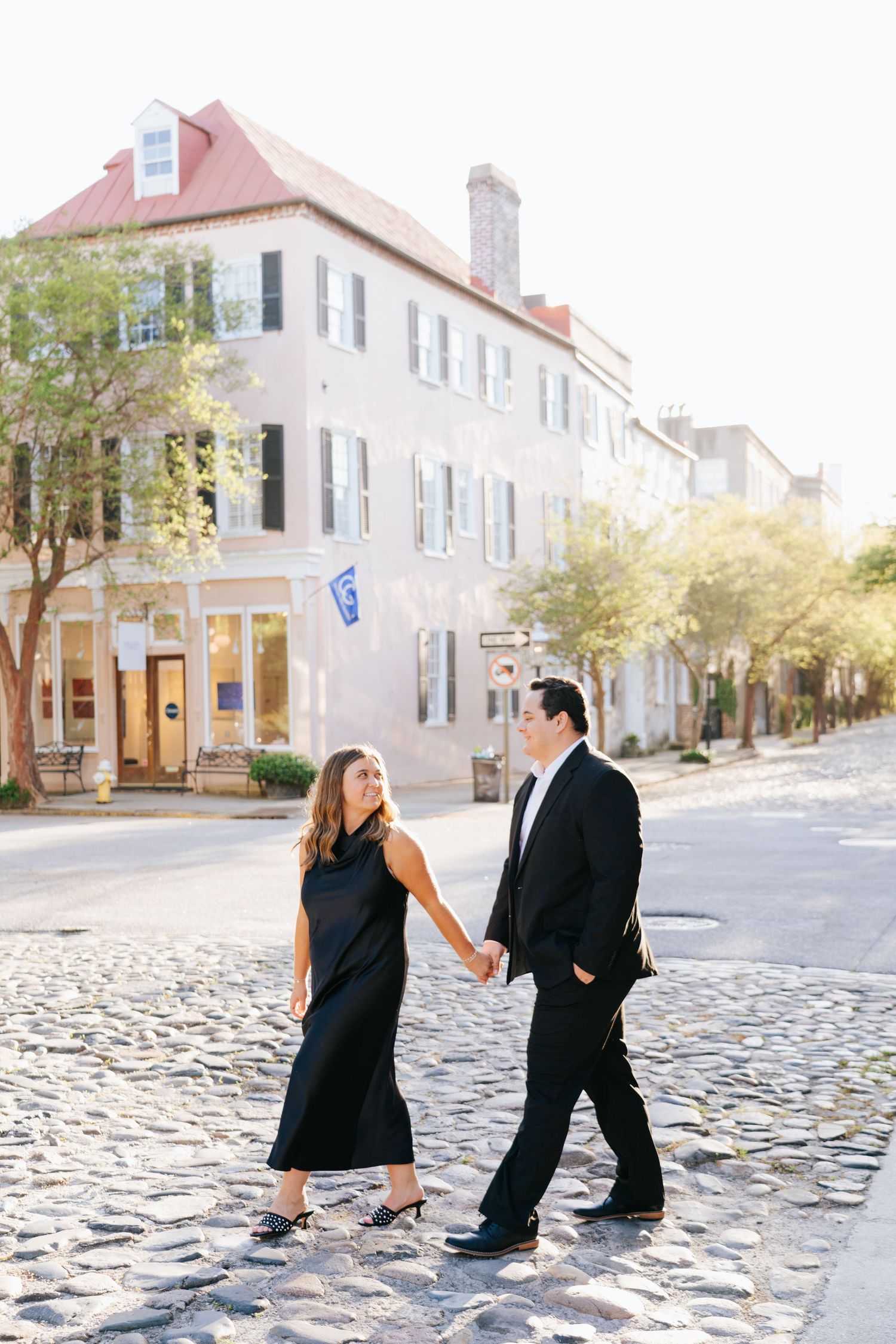 A couple playfully poses on historic cobblestone streets in Charleston's downtown district.