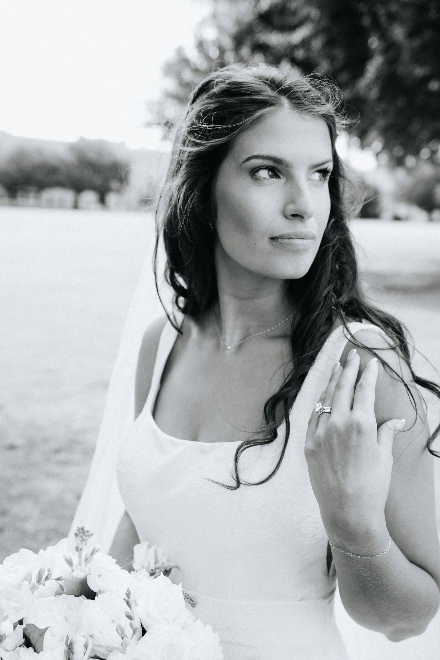 Black and white artistic bridal portrait showing elegant makeup and flowing hair.