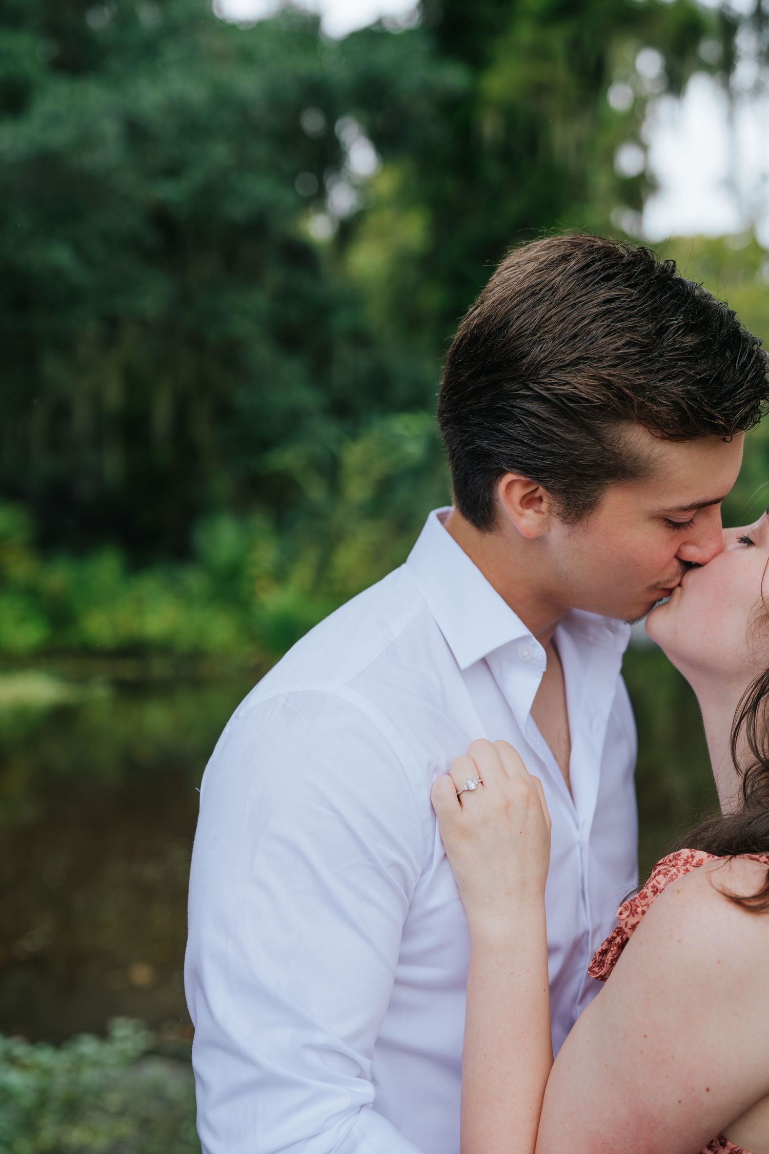 Intimate romantic moment shared between couple by a peaceful lake.