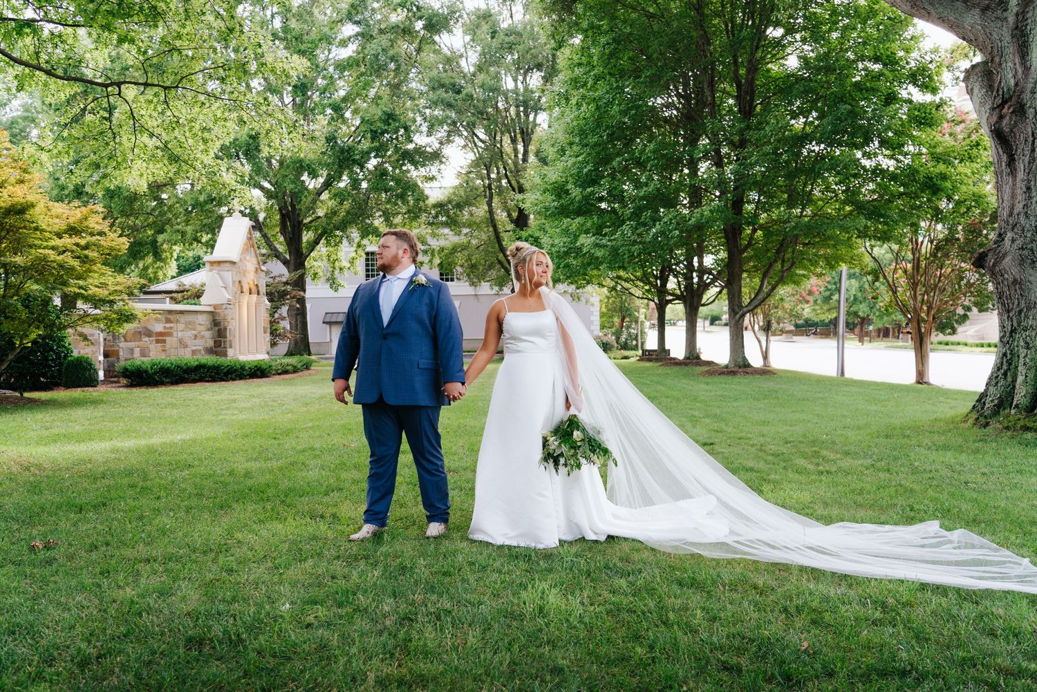 Elegant wedding portraits taken on a tree-lined path with natural greenery in the background.