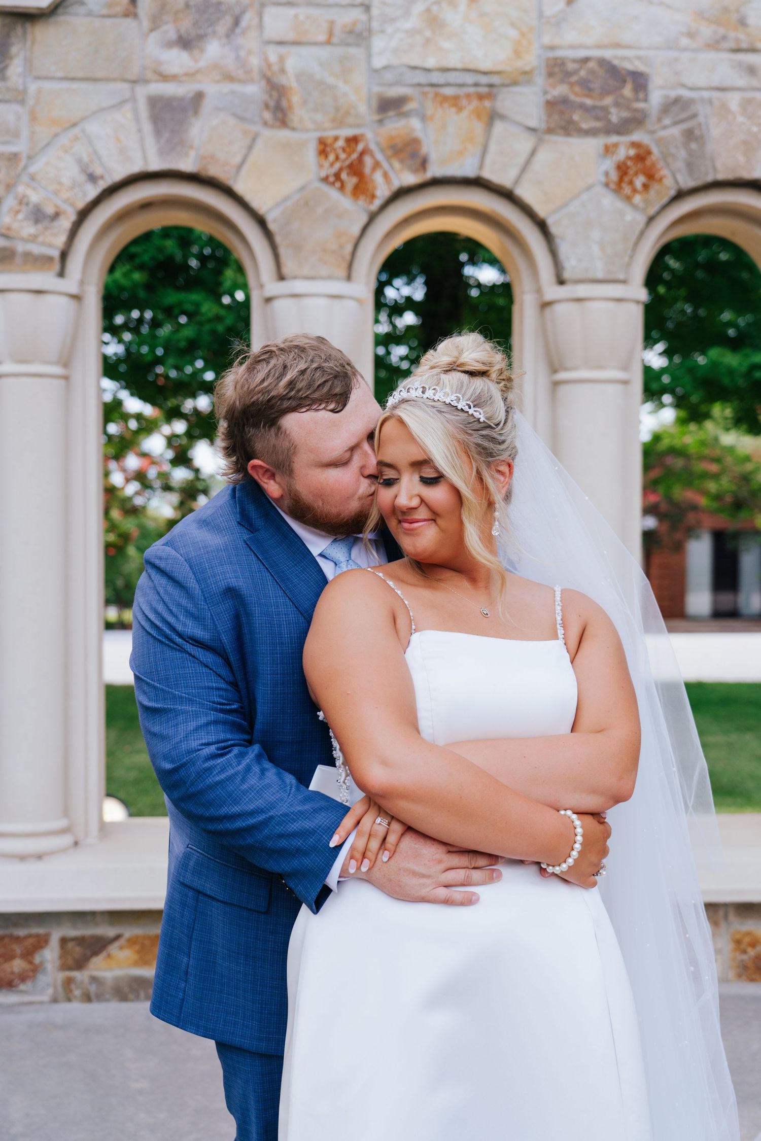 Romantic wedding portraits captured under stone archways with elegant architectural details.