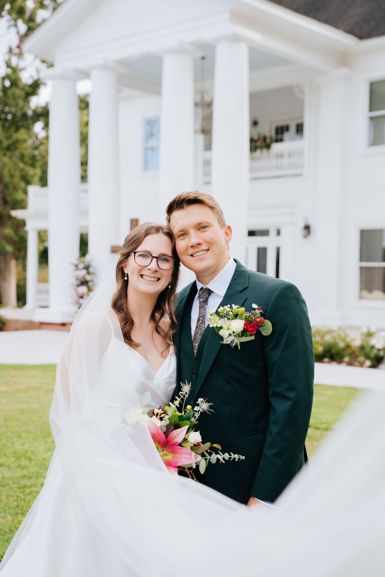 A romantic wedding photo series showing a couple embracing in front of white columns on a sunny day.