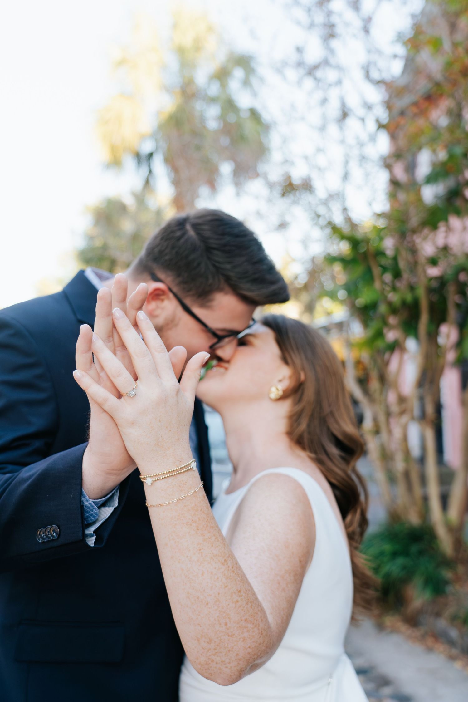 An intimate moment captured between a couple sharing a tender kiss outdoors.