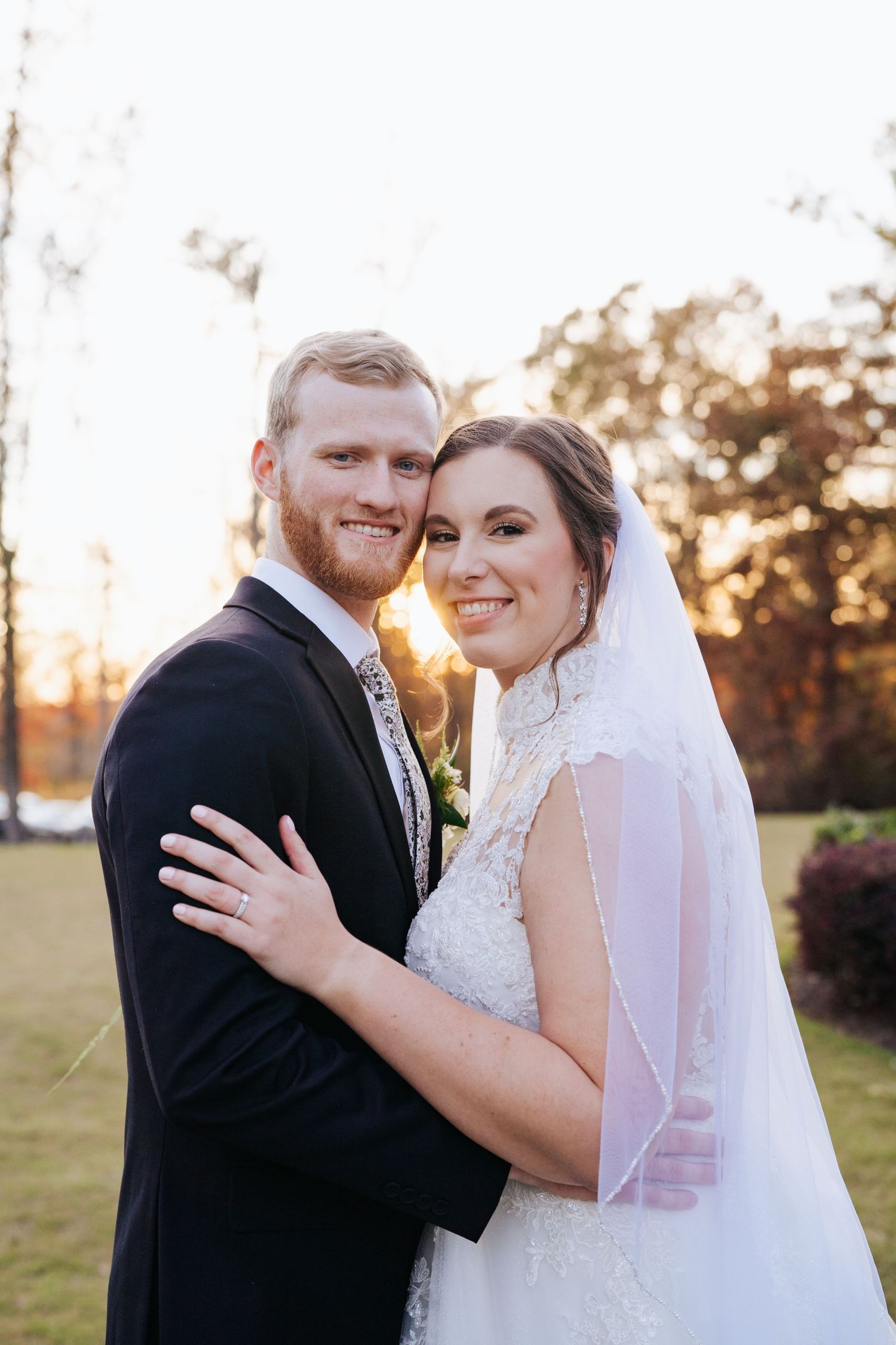 Romantic sunset wedding portraits with golden light filtering through trees.
