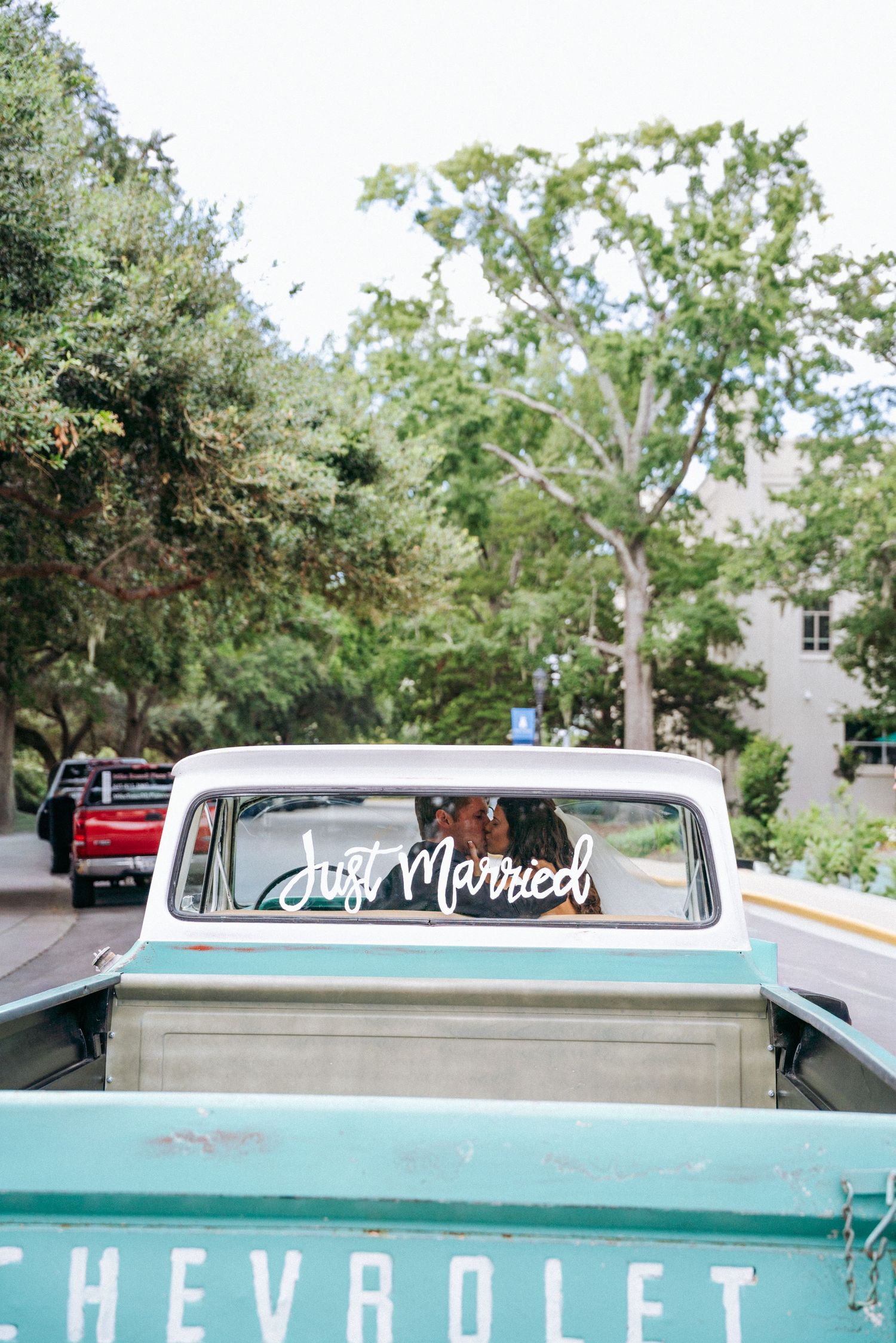 A mint green classic Chevrolet pickup truck decorated for a wedding.